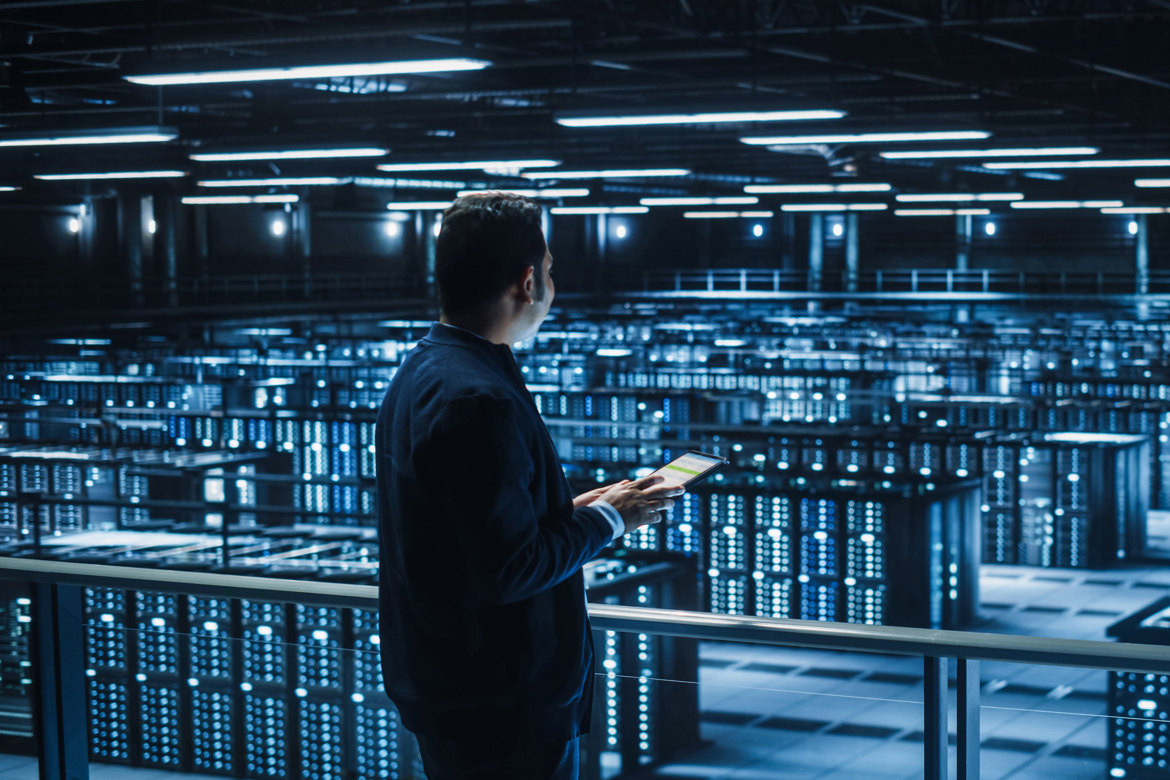 IT Specialist Using Tablet Computer in Data Center