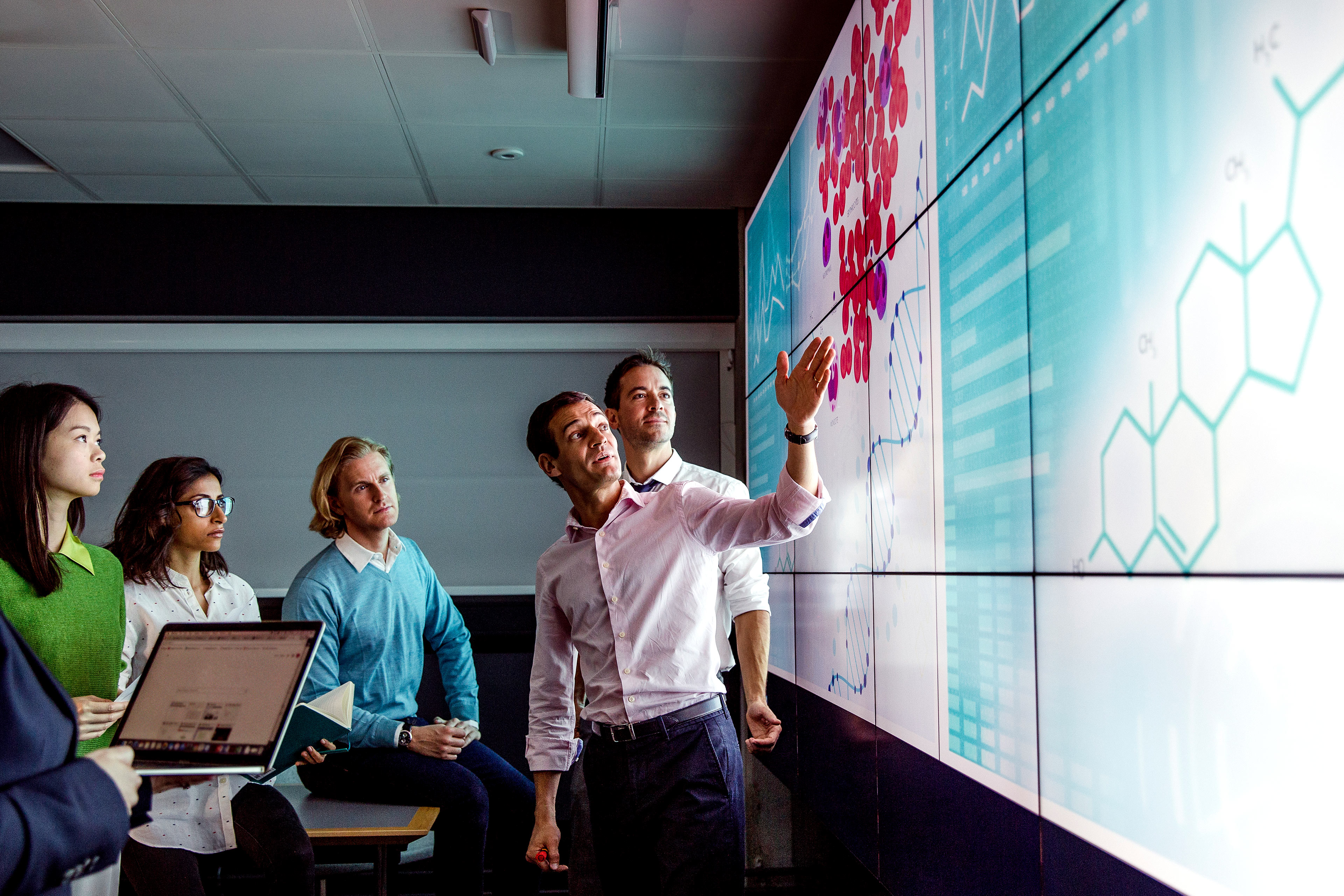 Adults viewing data on a large display screen