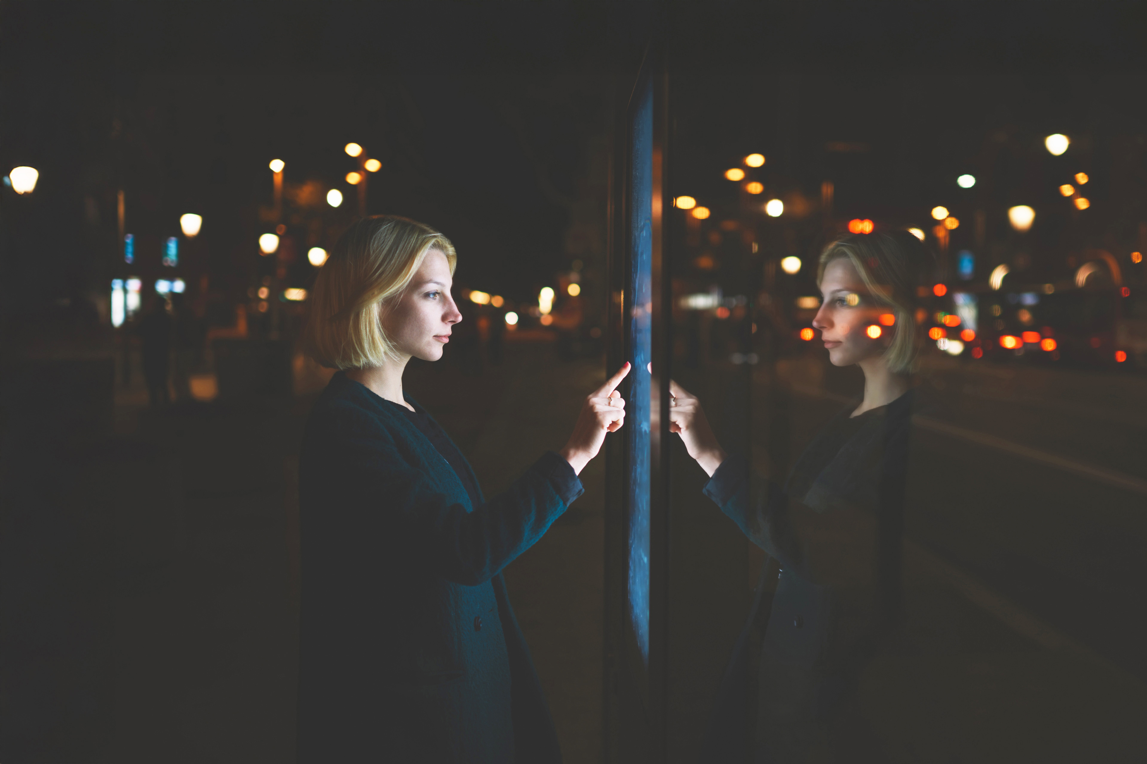 Businesswoman in front of reflective screen.