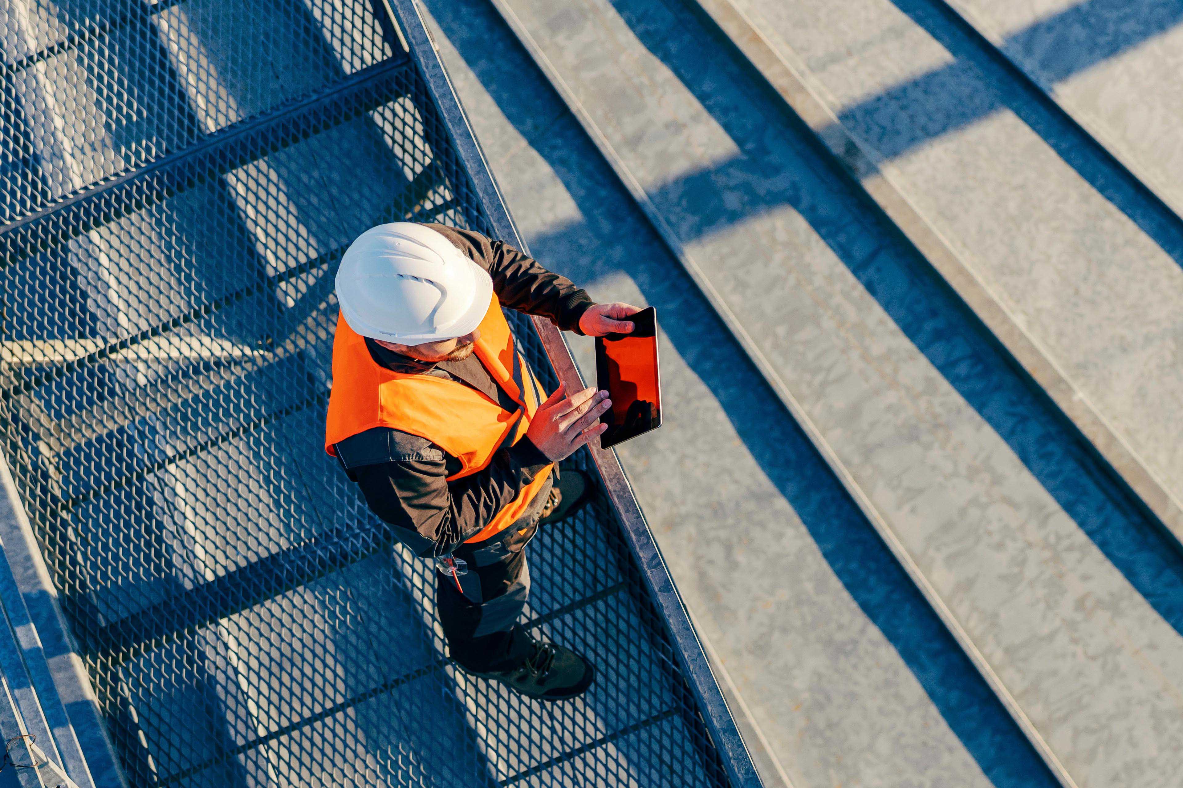 Top view of an industry worker standing on height and checking on silo supply