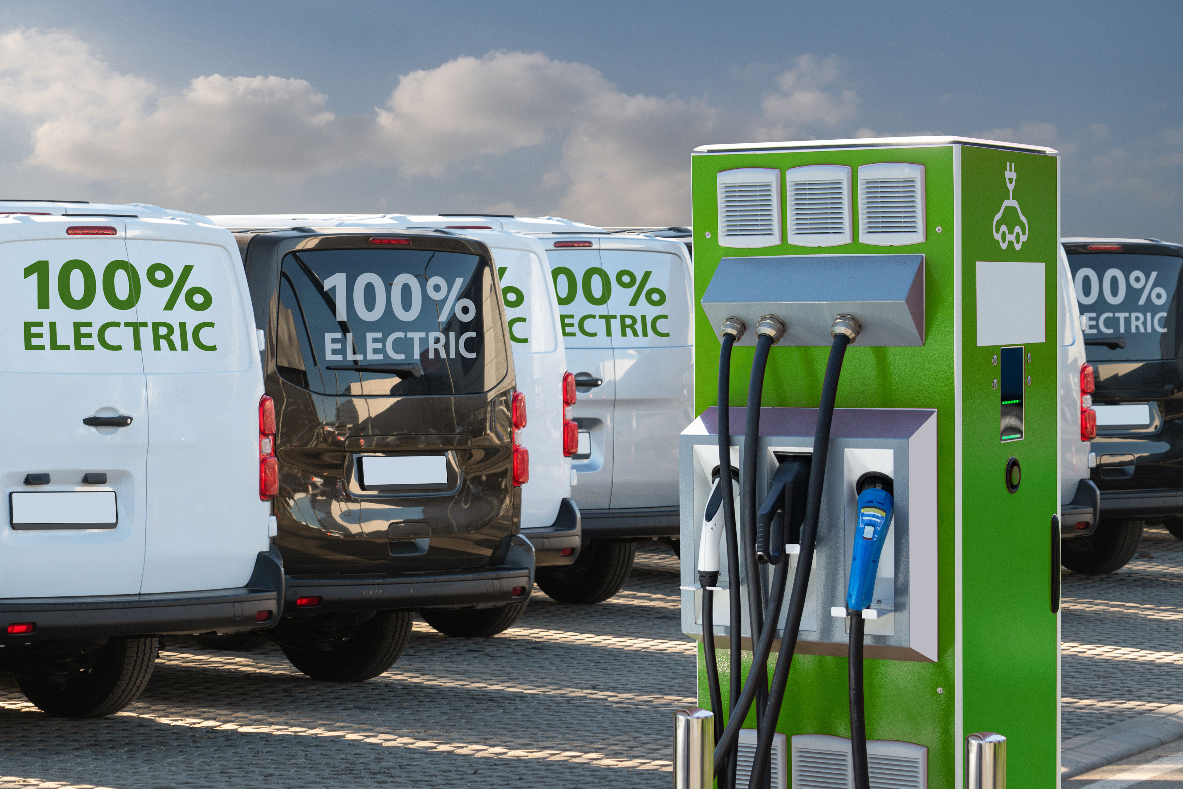 Electric vehicles charging station on a background of a row of vans