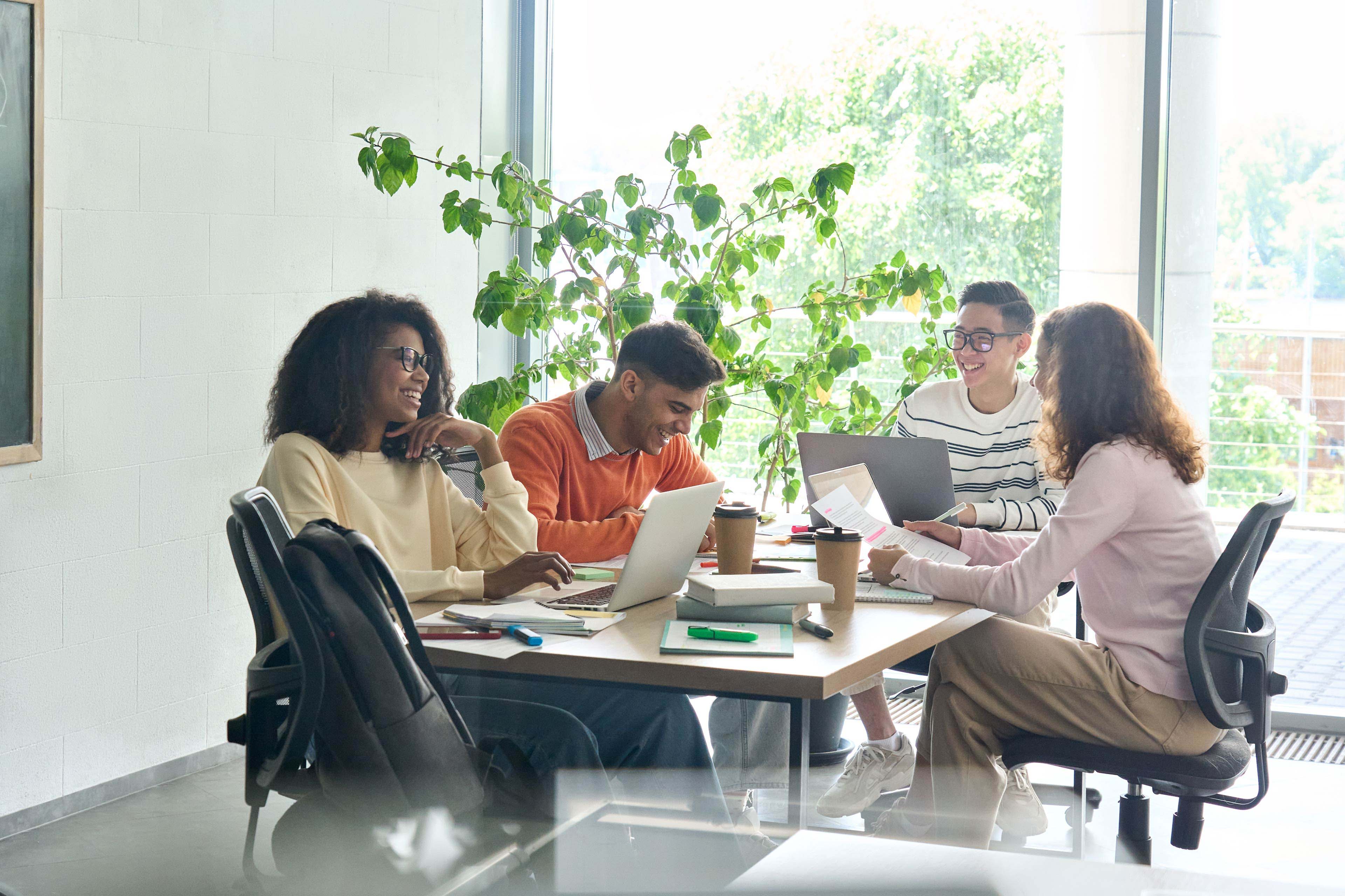 Four happy colleagues working in the office