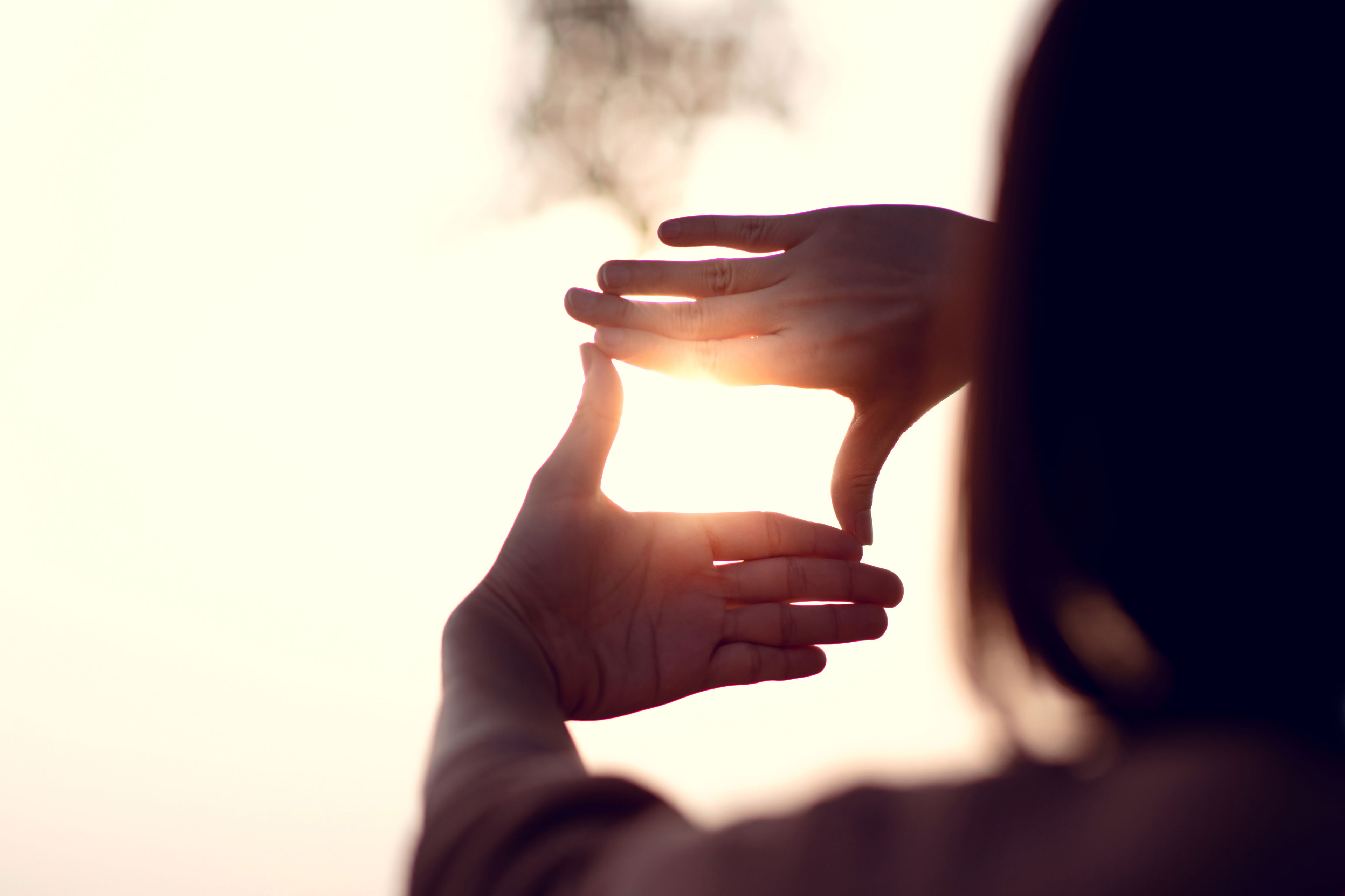 Hands making frame gesture with sunset