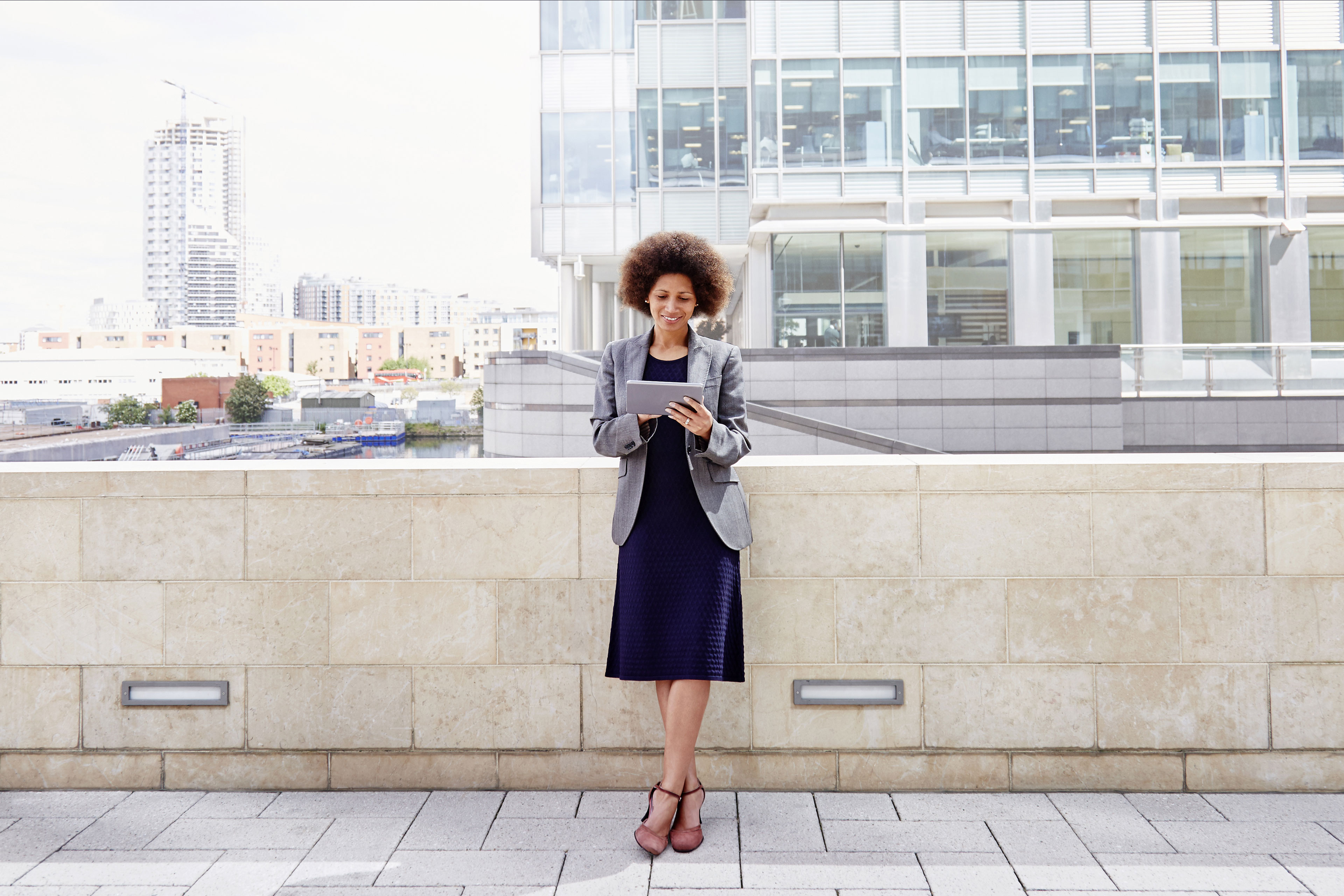 Mixed-race businesswoman using tablet in city