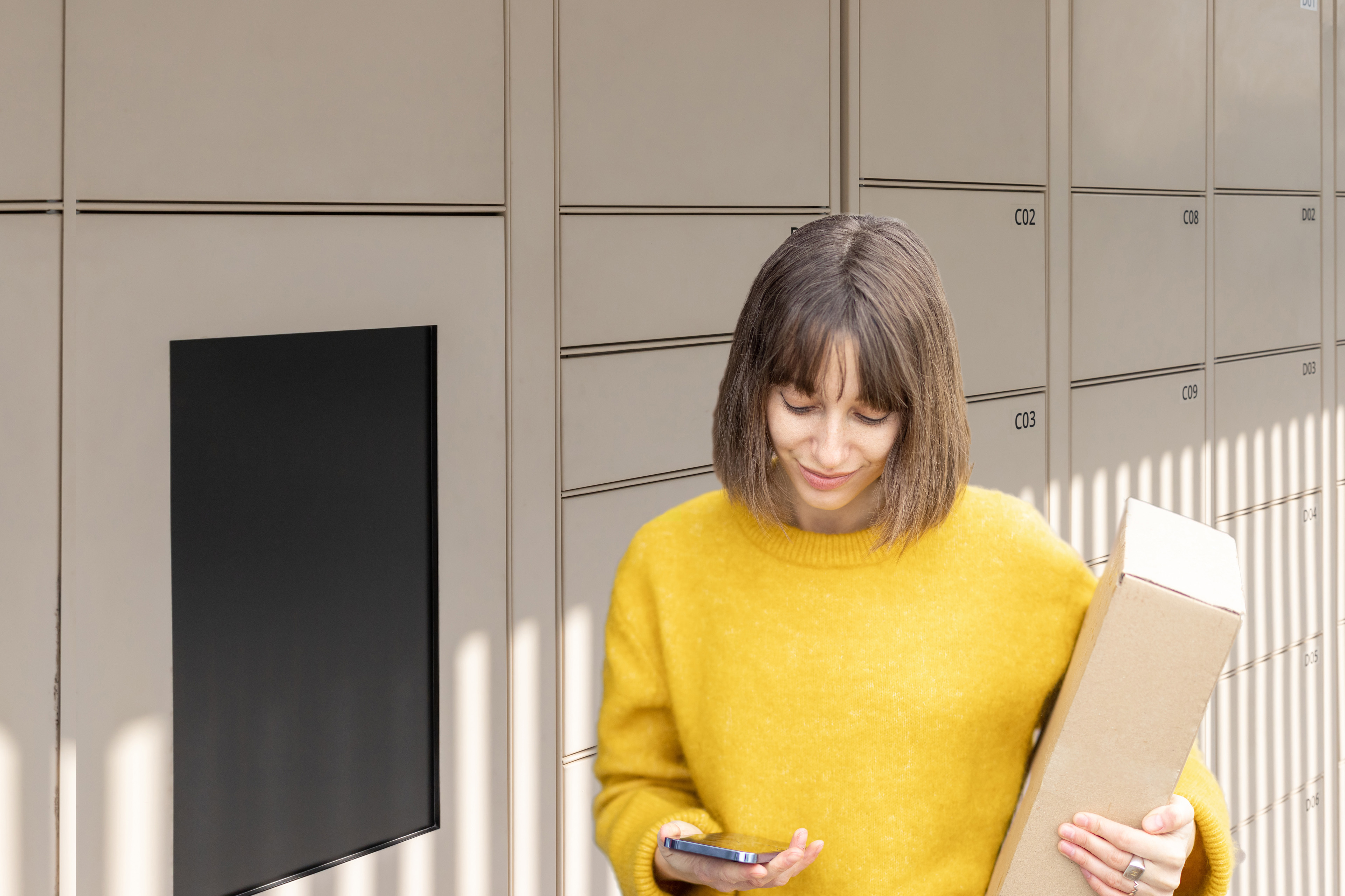 Woman retrieving package from smart locker with phone app