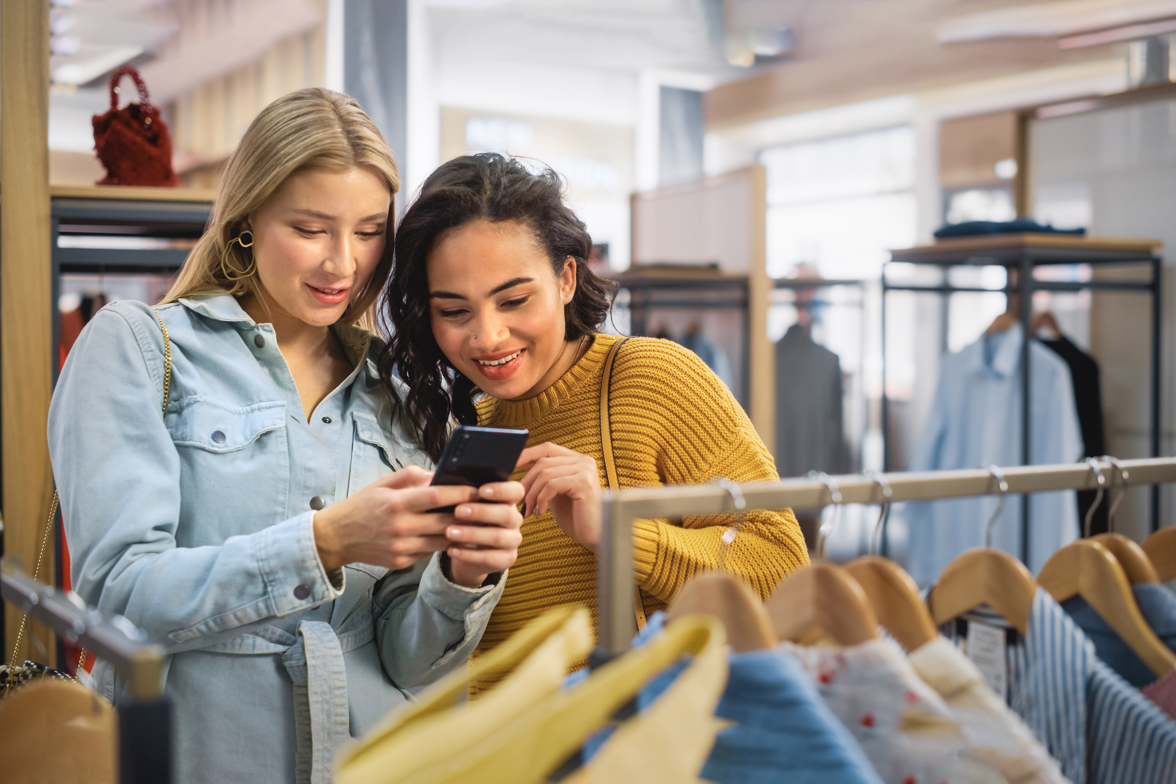 Two Beautiful Female Friends Shopping in Clothing Store