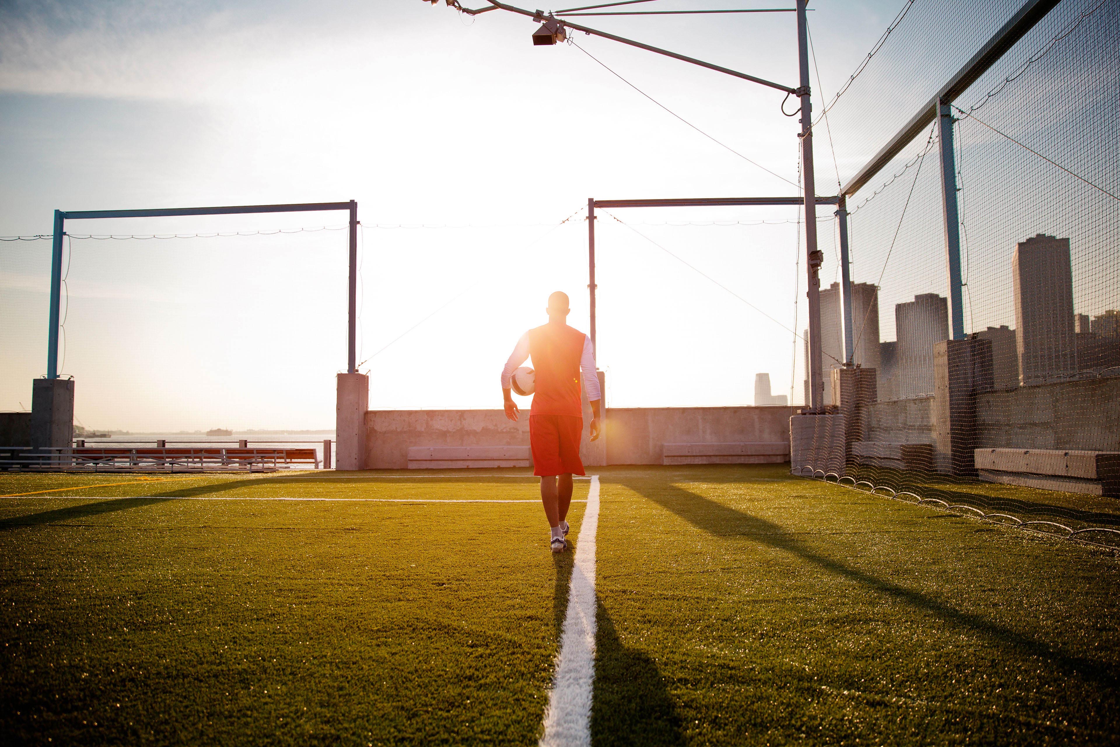 Male player walking across soccer field