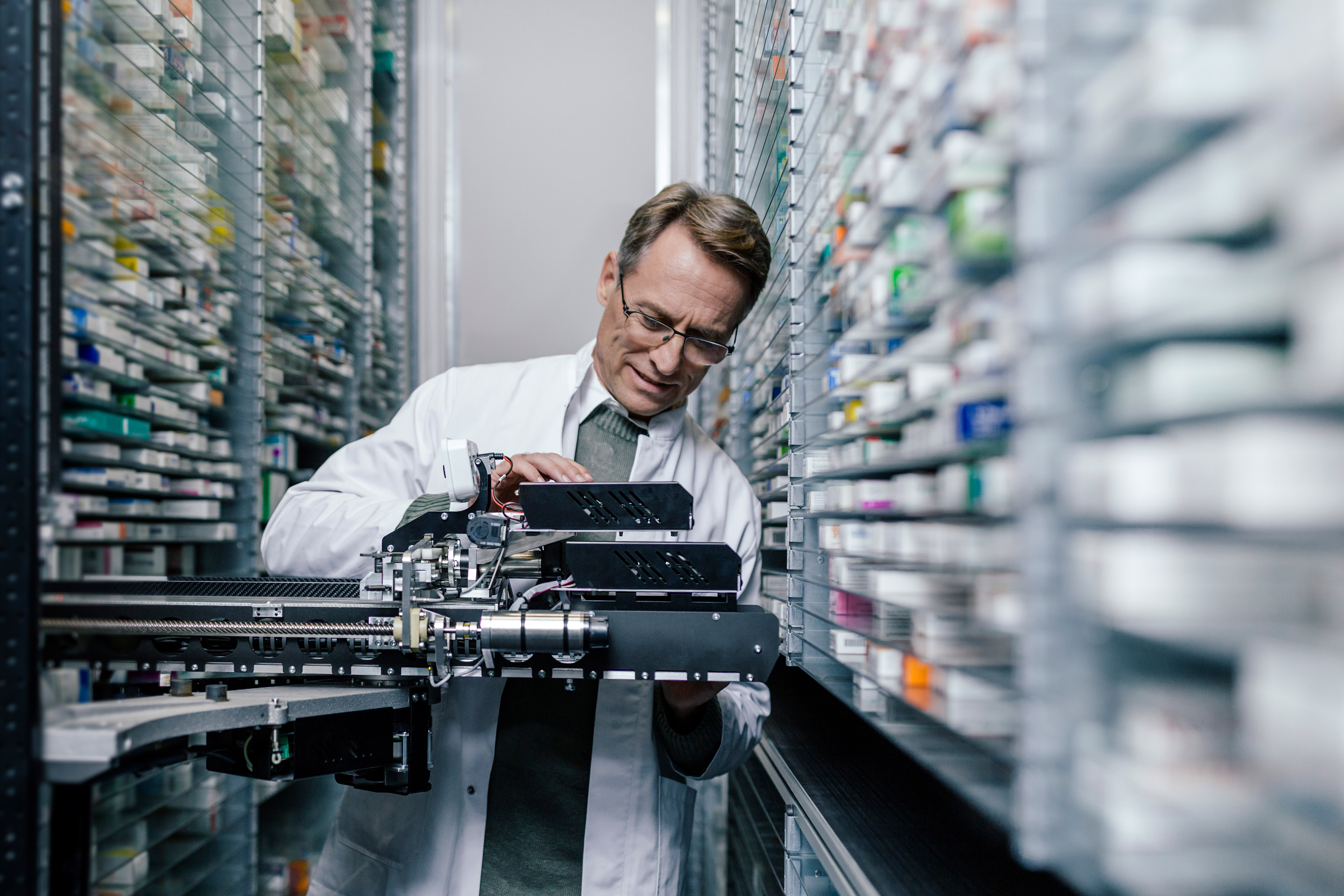 Pharmacist examining machine in pharmacy