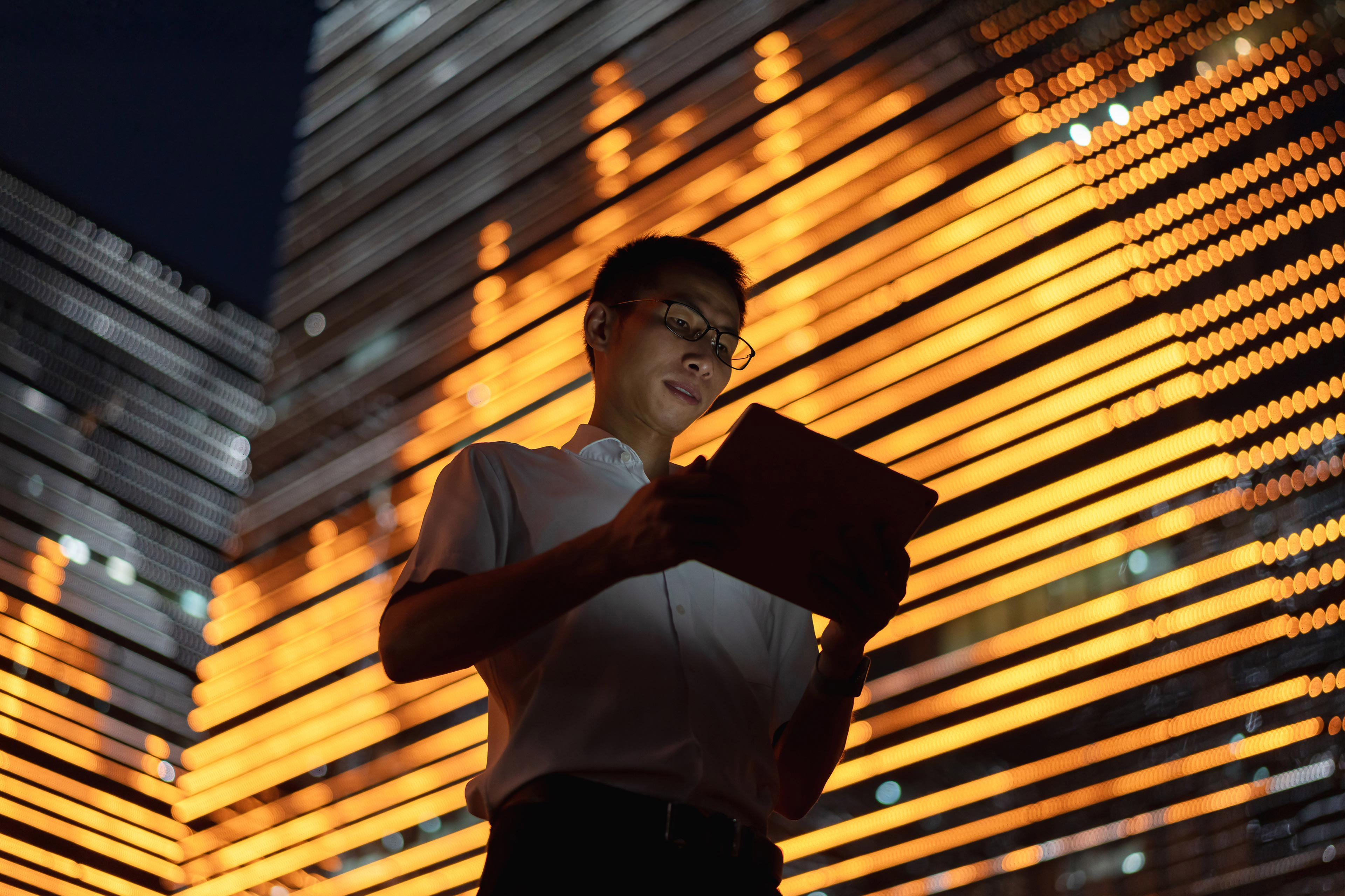 Male white-collar worker uses a tablet computer outdoors