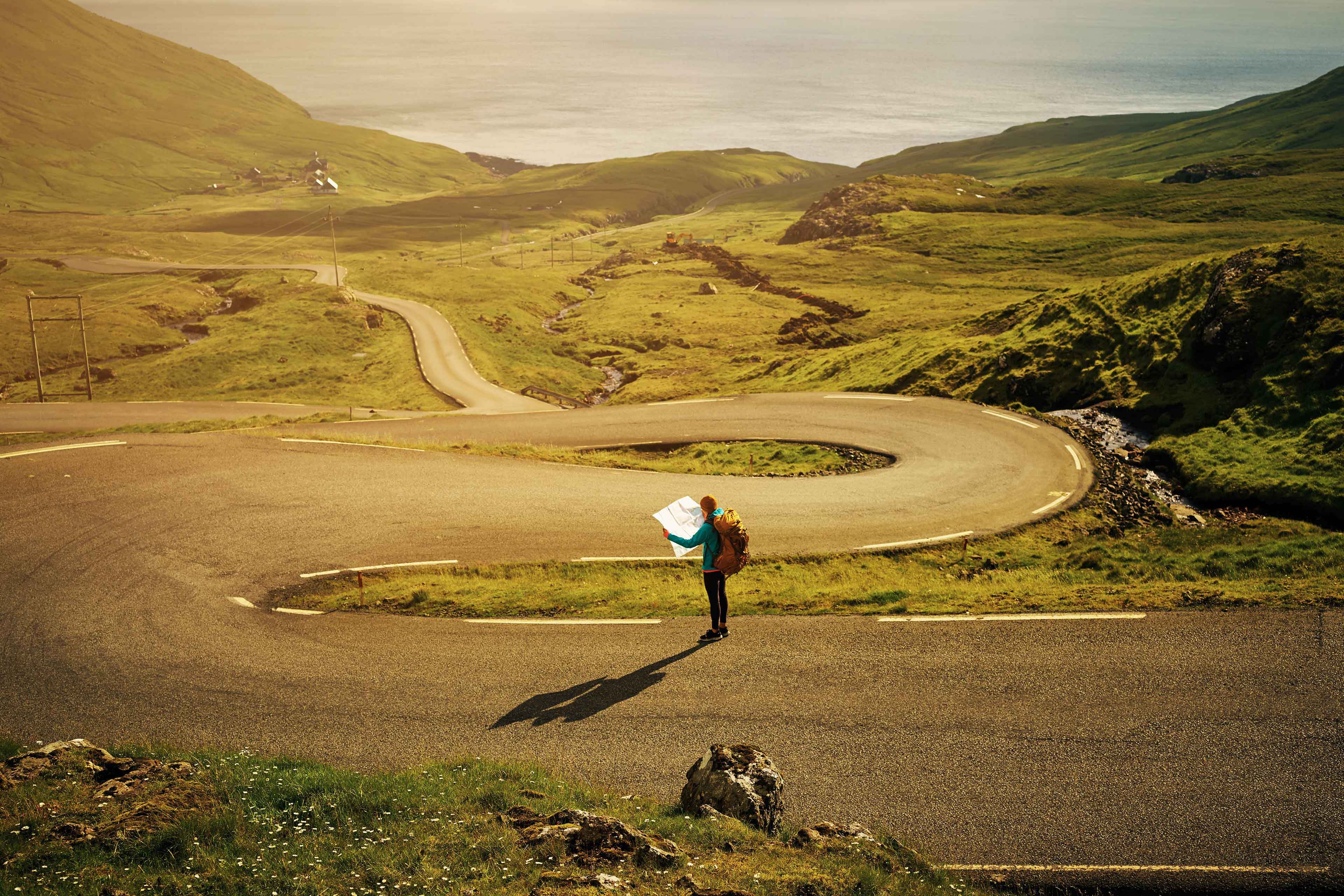 EY Young Woman in the middle of a road reading map