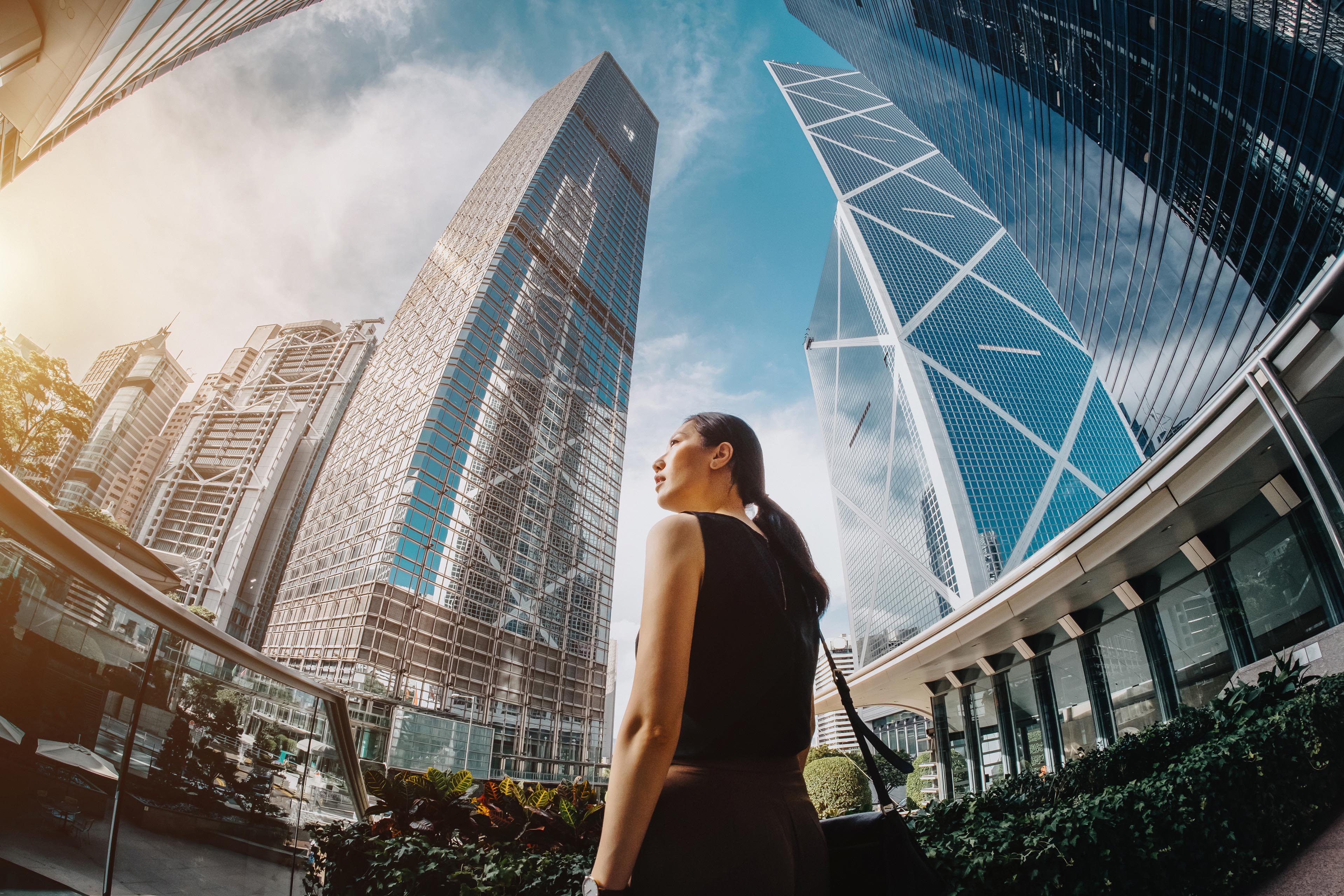 Asian businesswoman looking at highrise towers