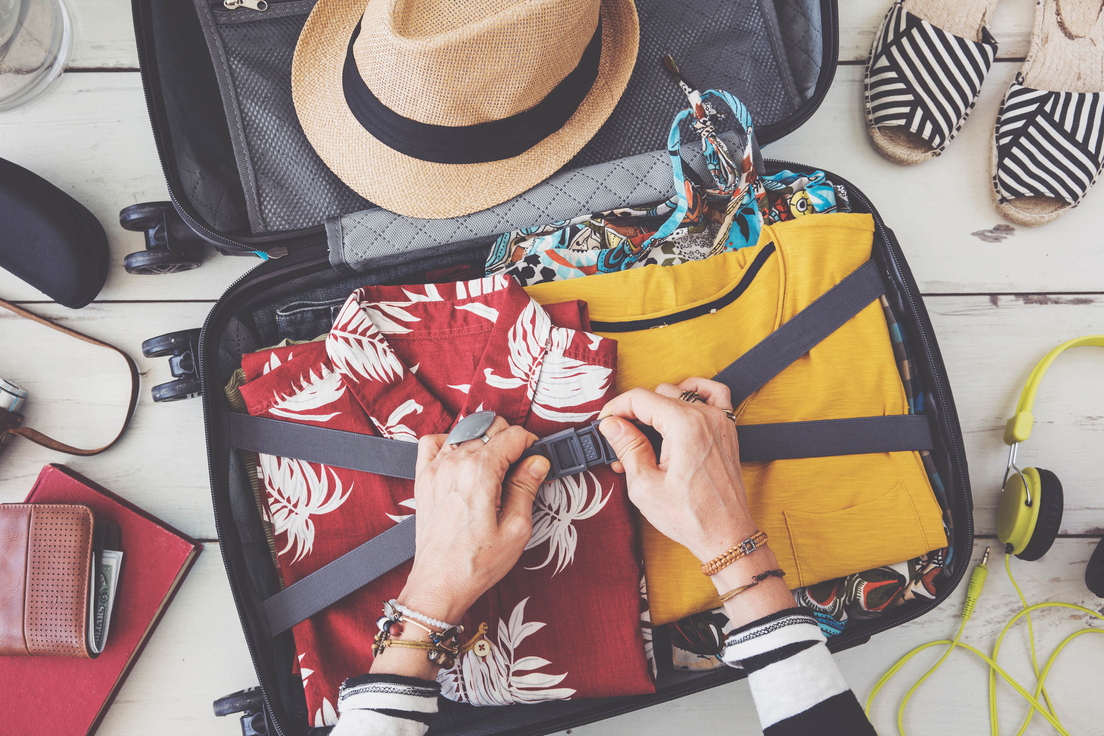 Woman hand preparing summer luggage