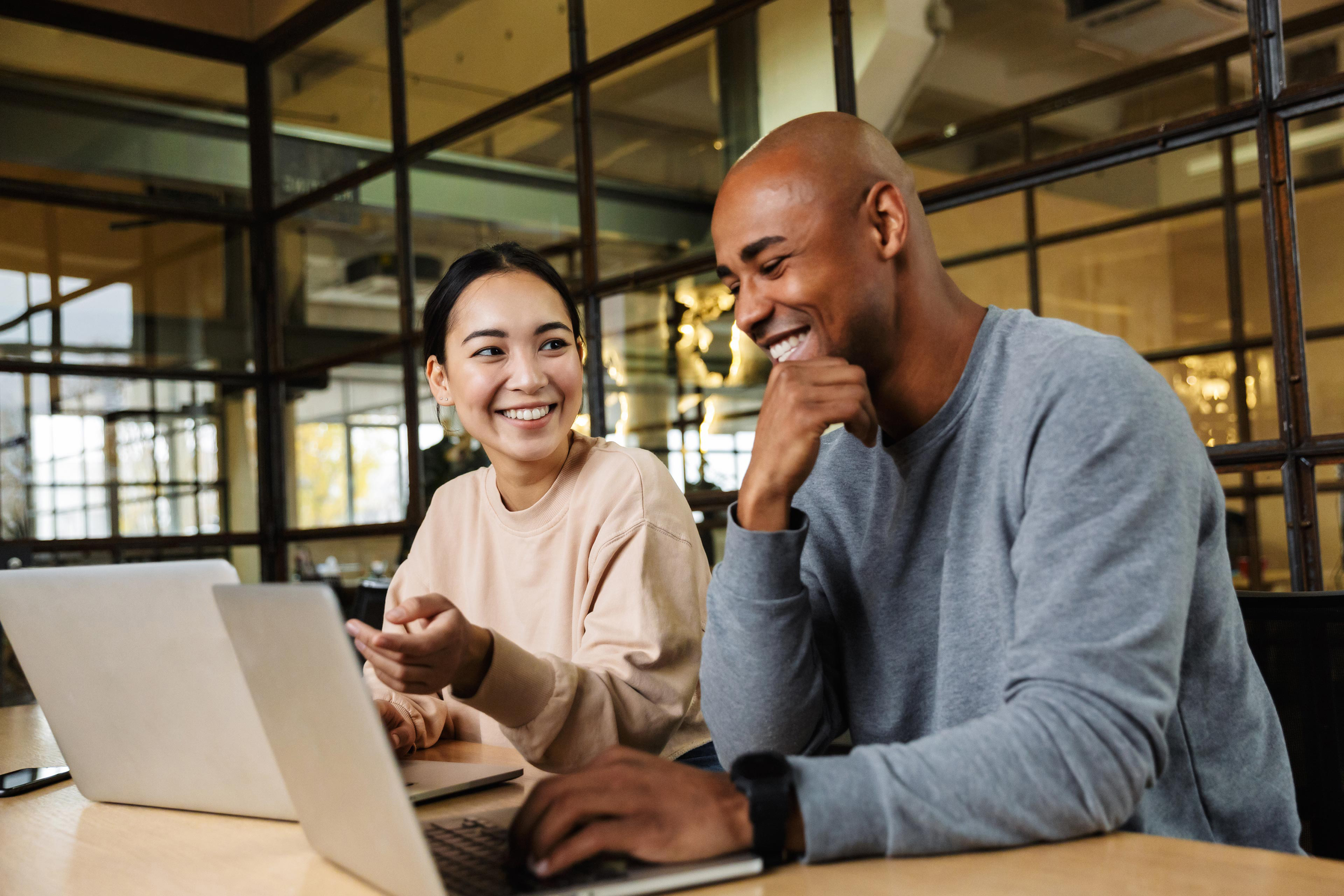 Multiethnic coworkers working on laptops in office