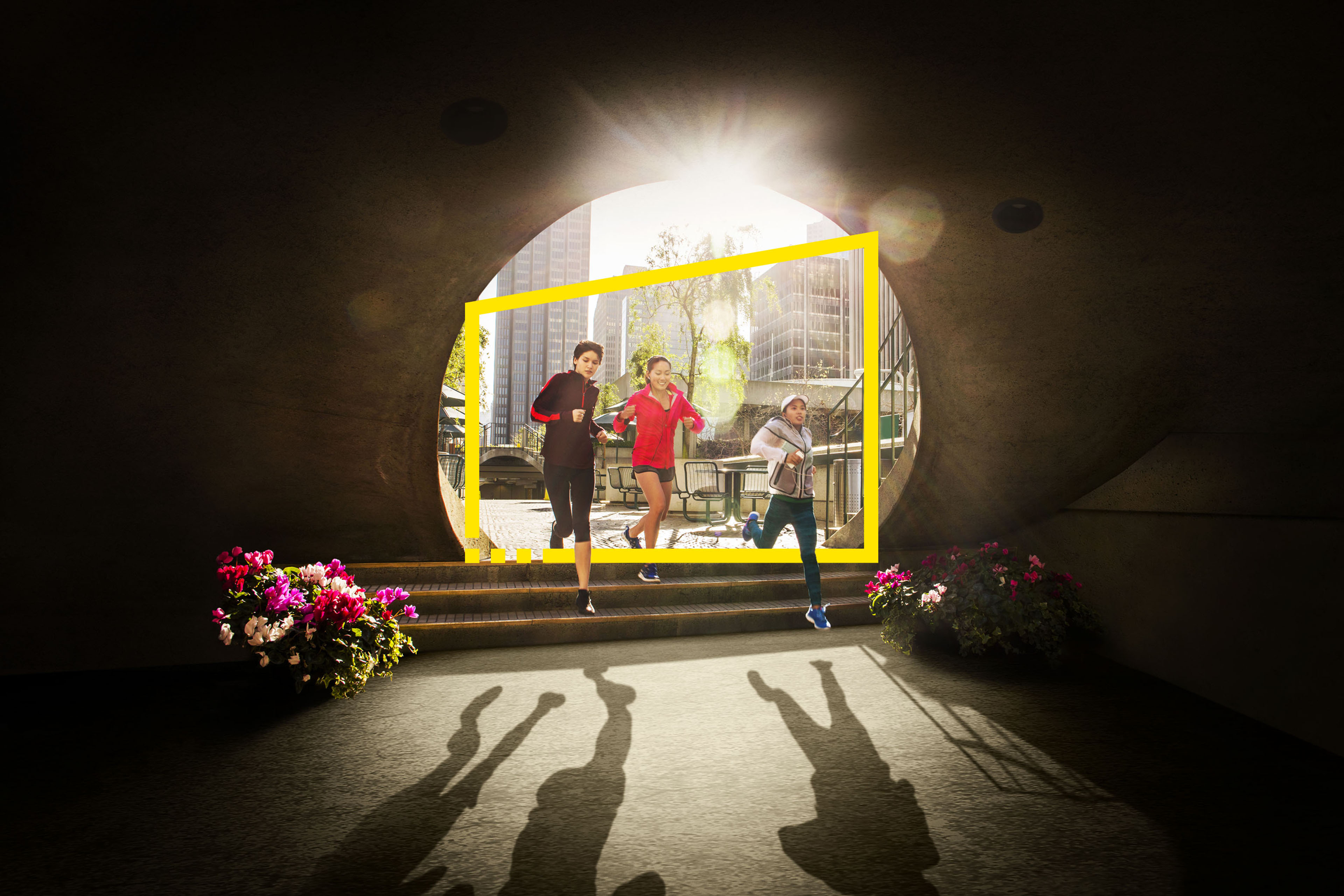 Women running through arch in urban park metadata image