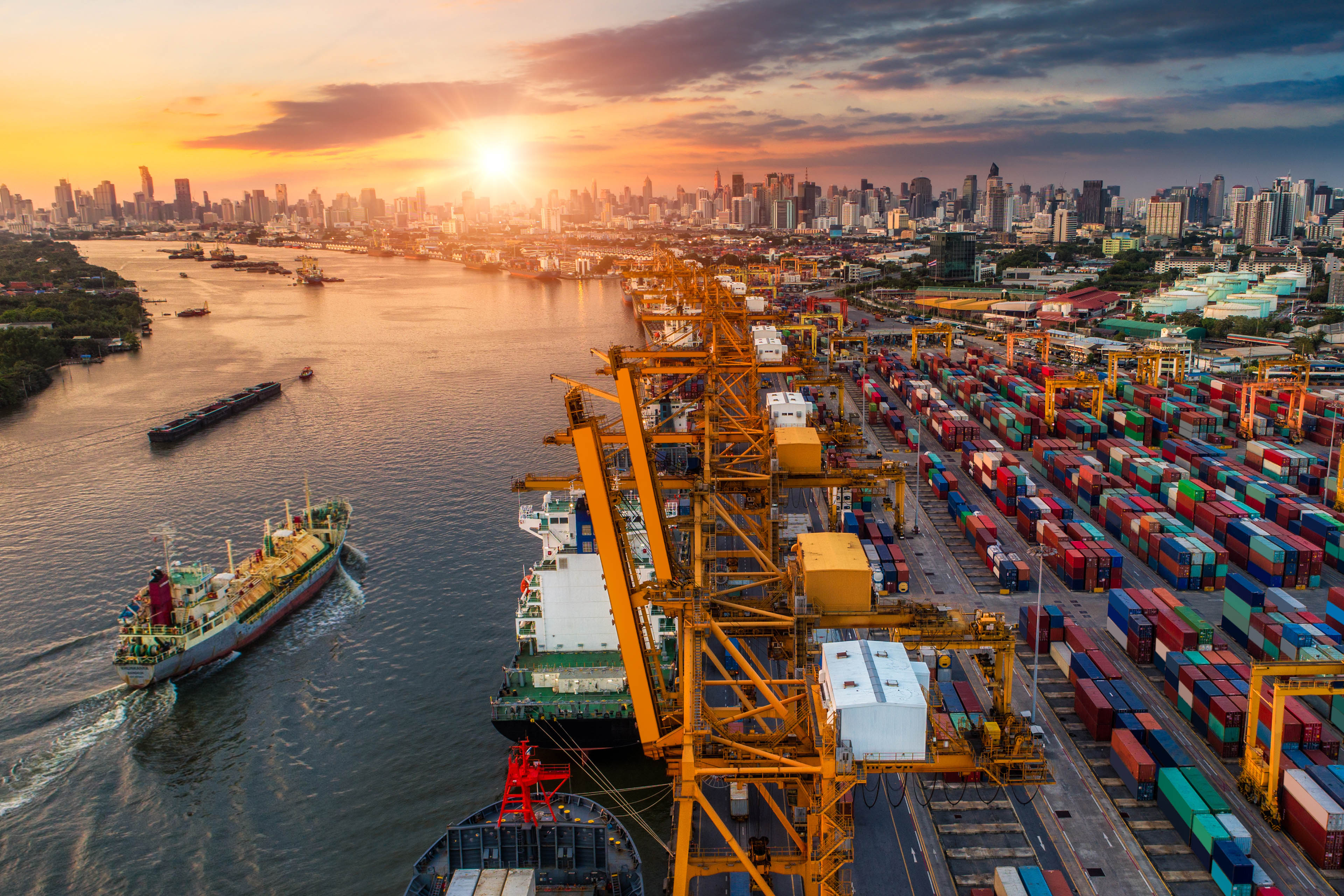 Logistics and transportation of Container Cargo ship and Cargo plane with working crane bridge in shipyard at sunrise, logistic import export and transport industry background