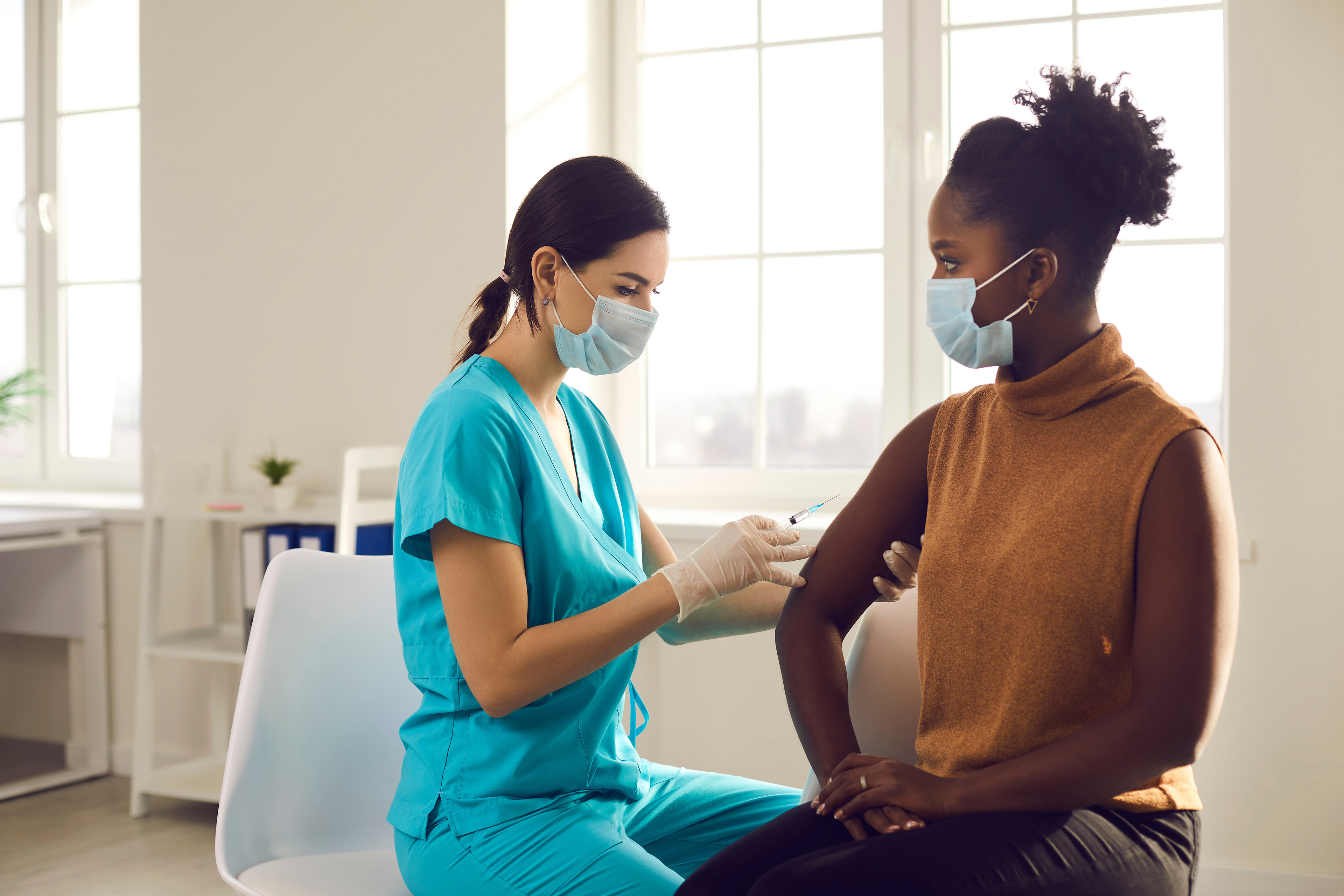 Young African-American woman sitting at doctor's office and gett