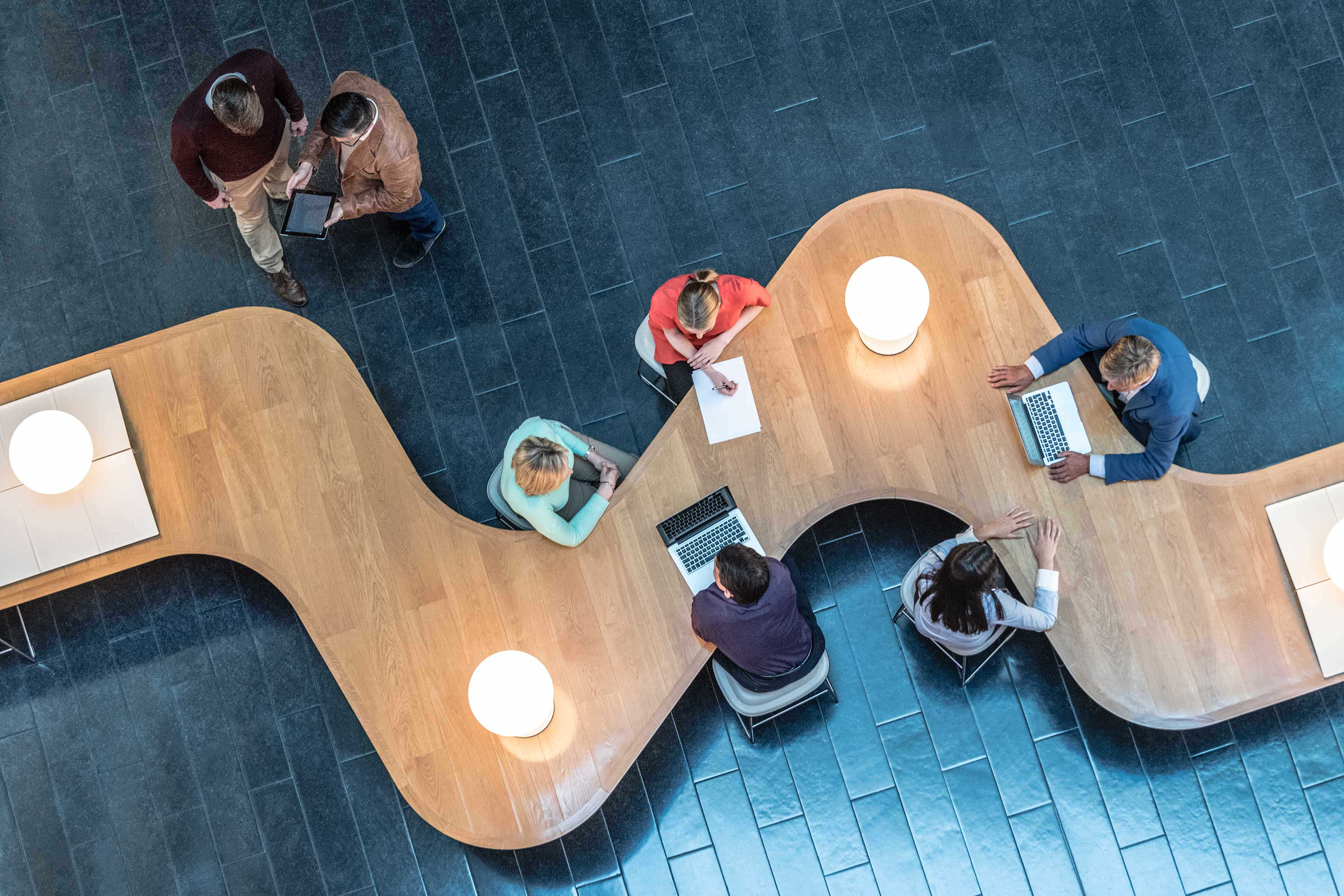 Office workers sitting at curved desk in business meeting