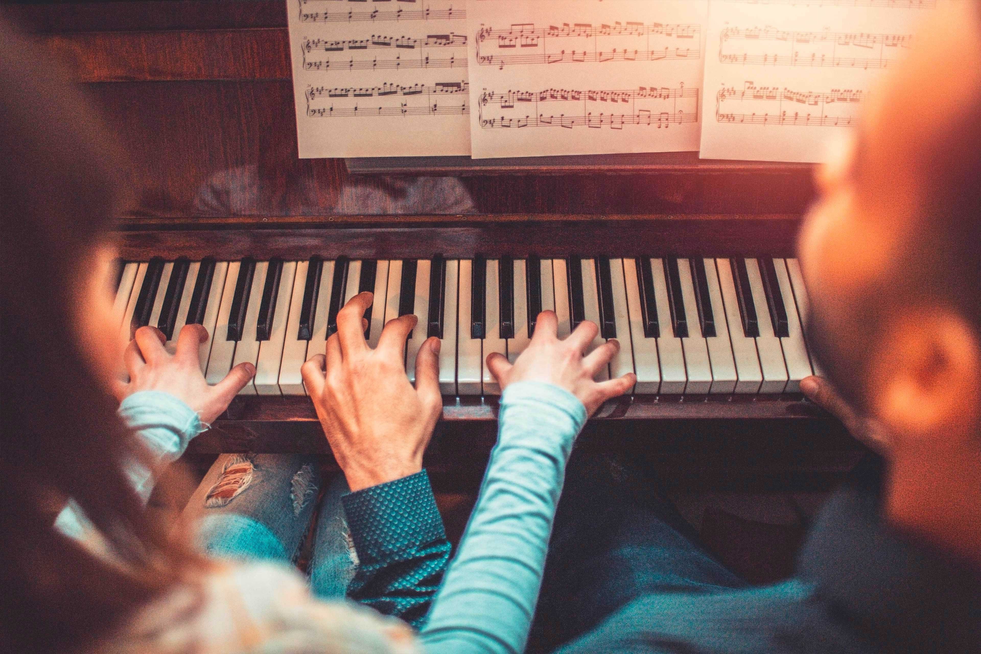 Young adults playing piano together