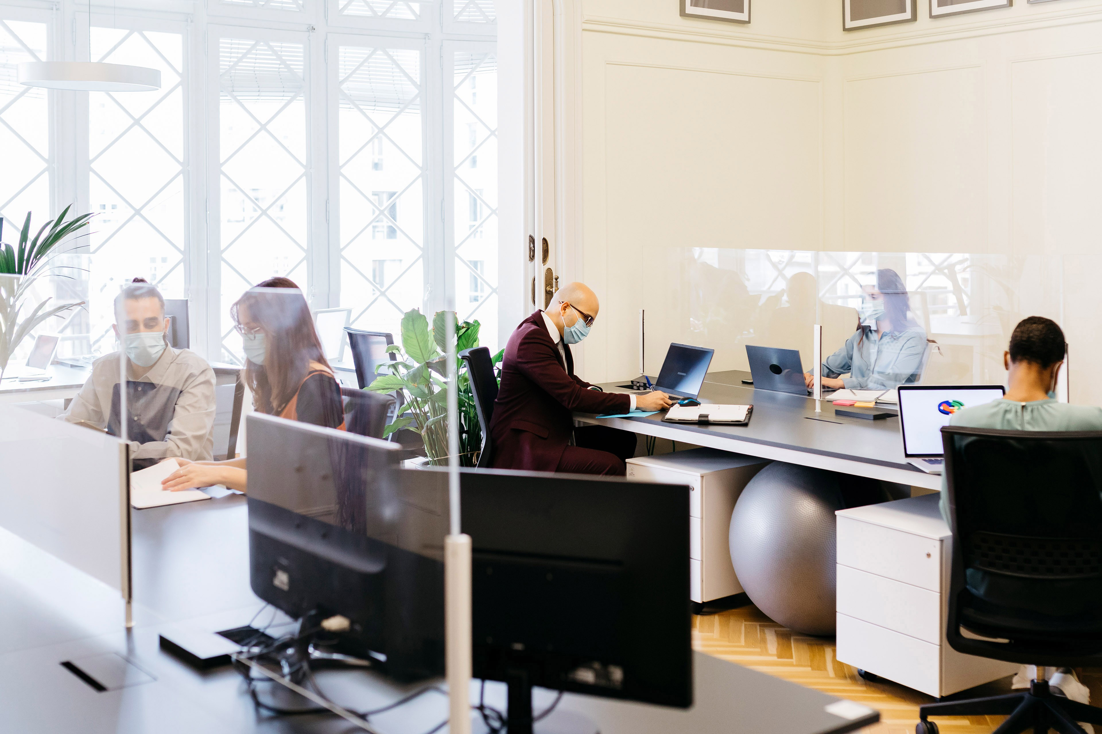 Business professionals with protective mask working at desk in office