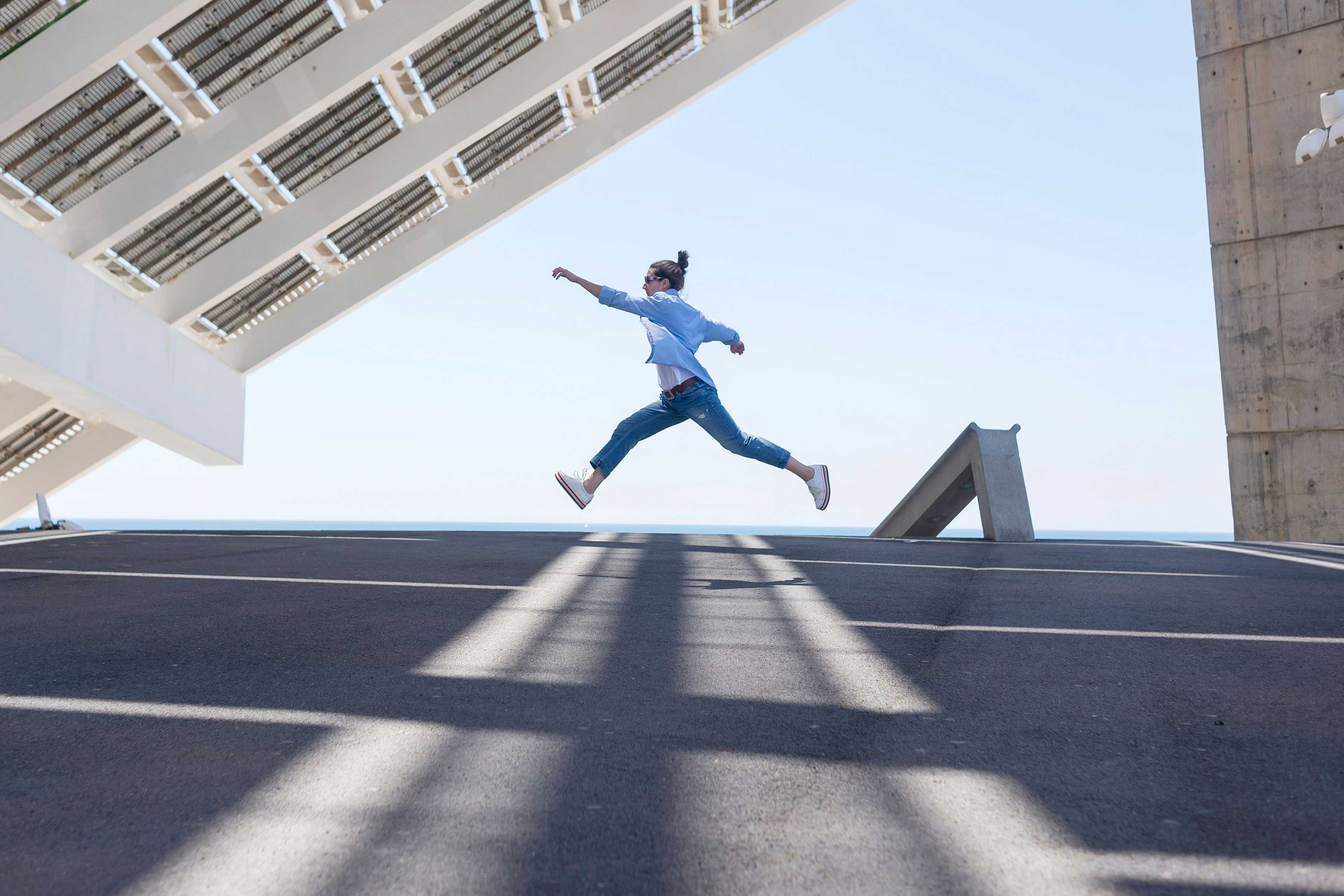 ey man leaping under solar panels