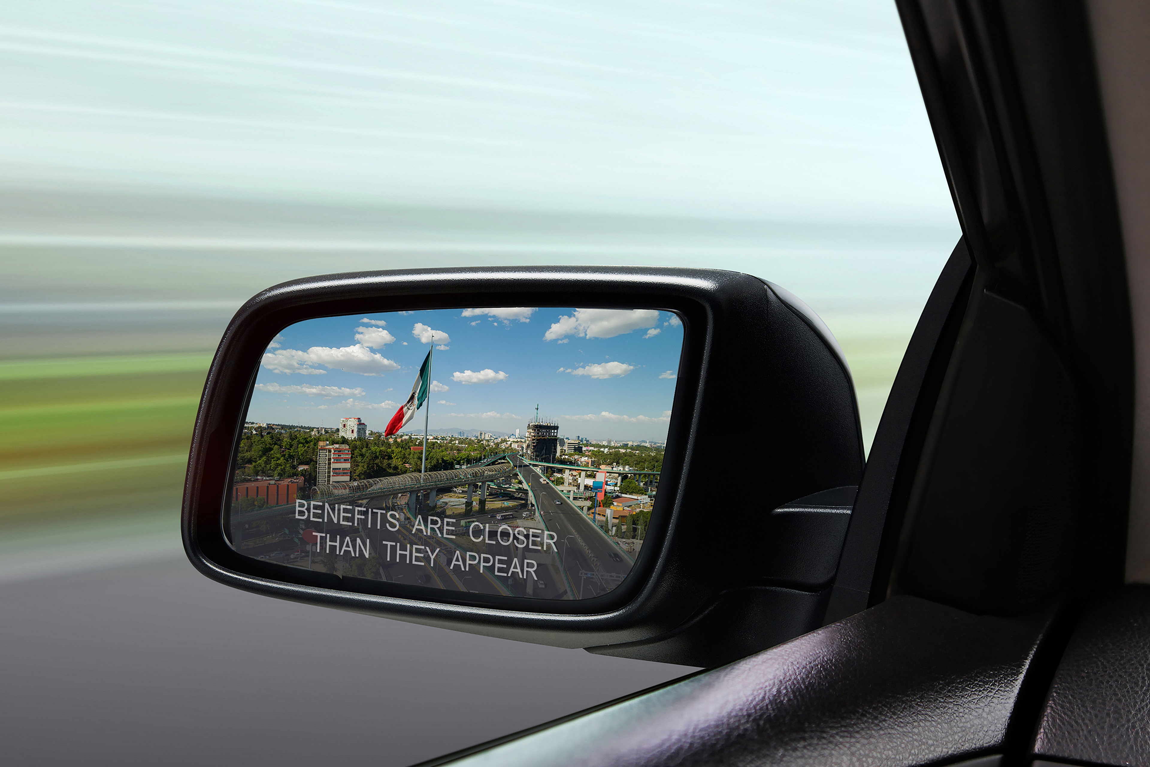 Reflection of traffic flow in left side rear view mirror at twilight time