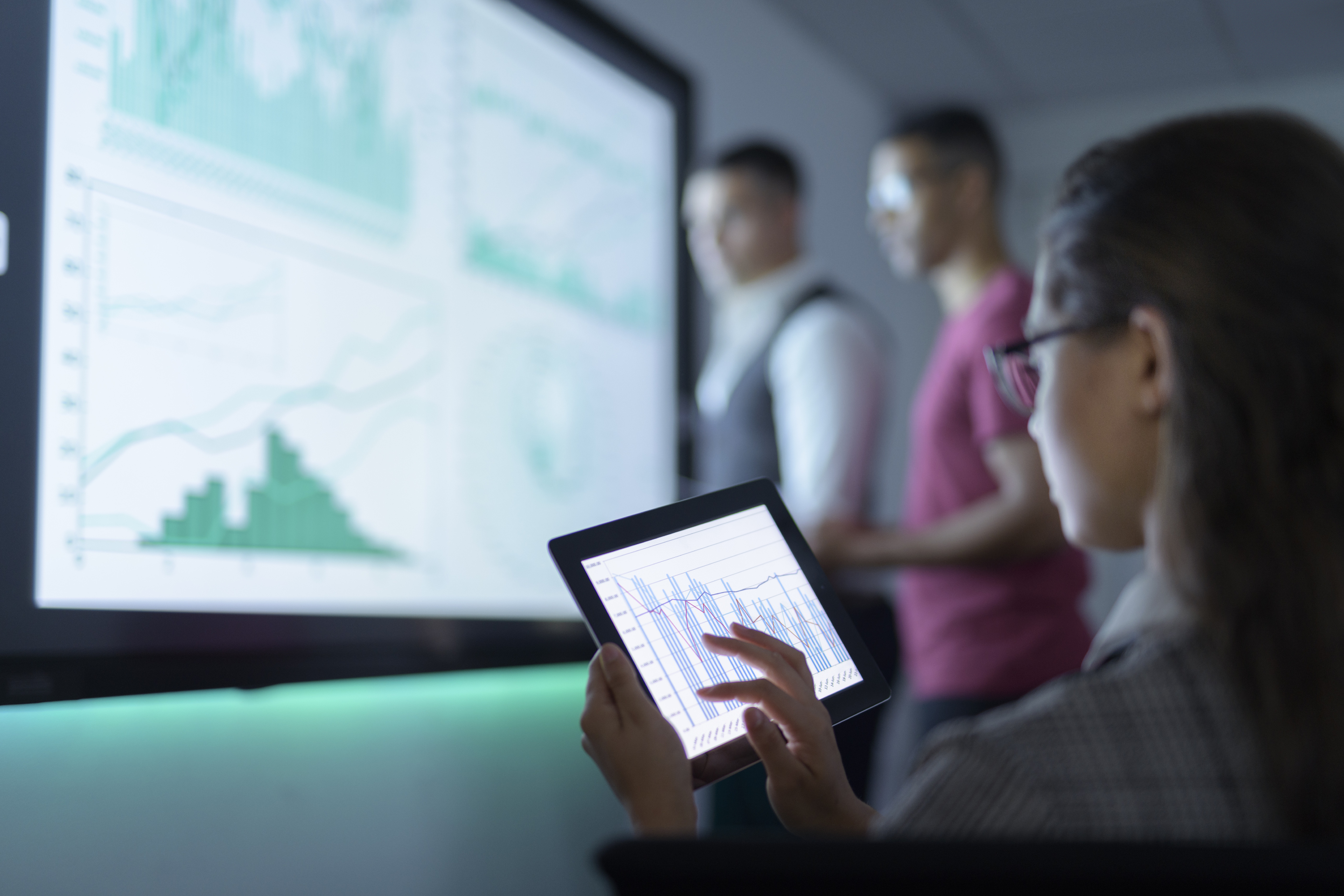 Businesswoman viewing graphs on digital tablet in business meeting