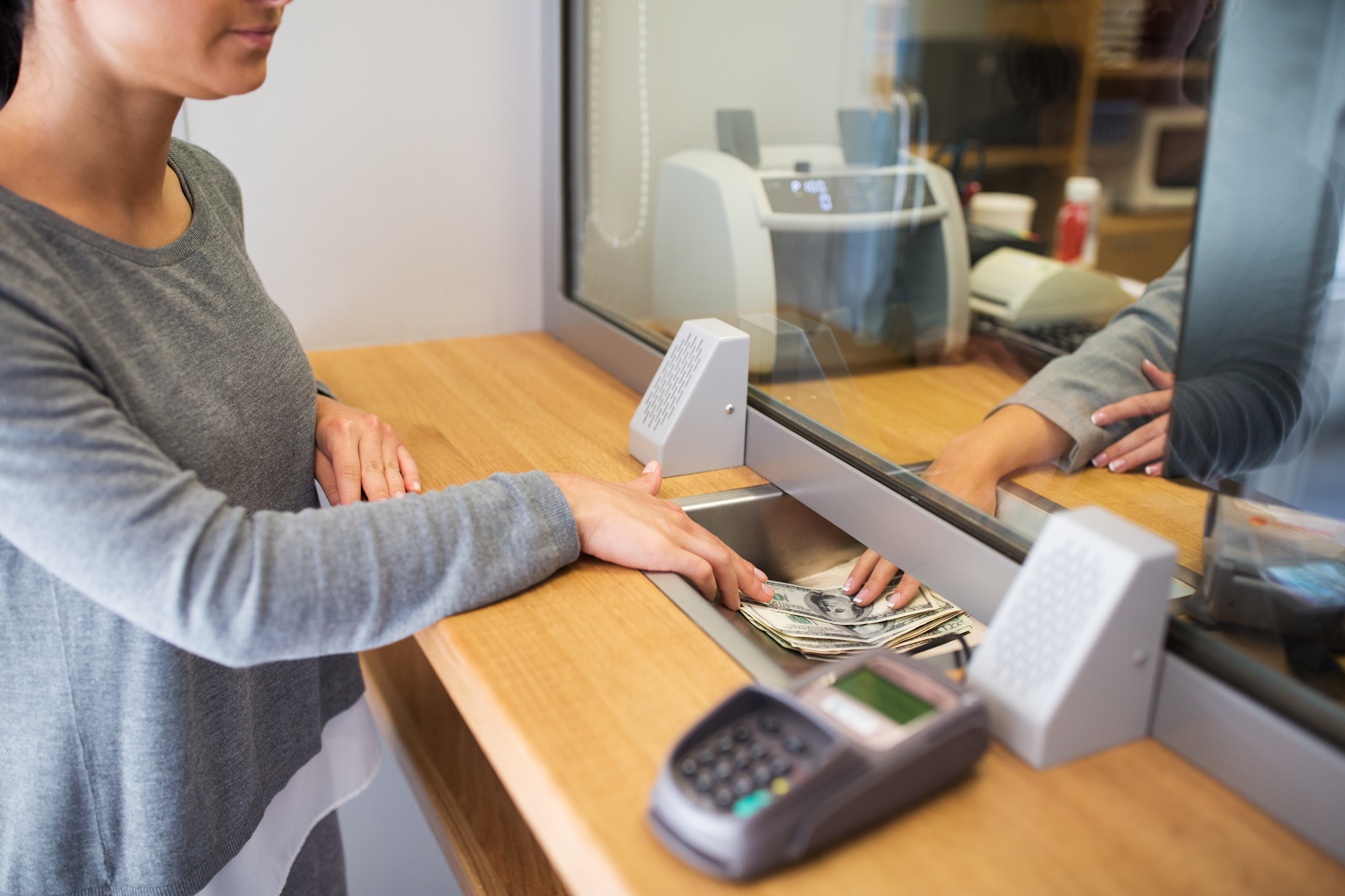 Clerk giving cash money to customer at bank office