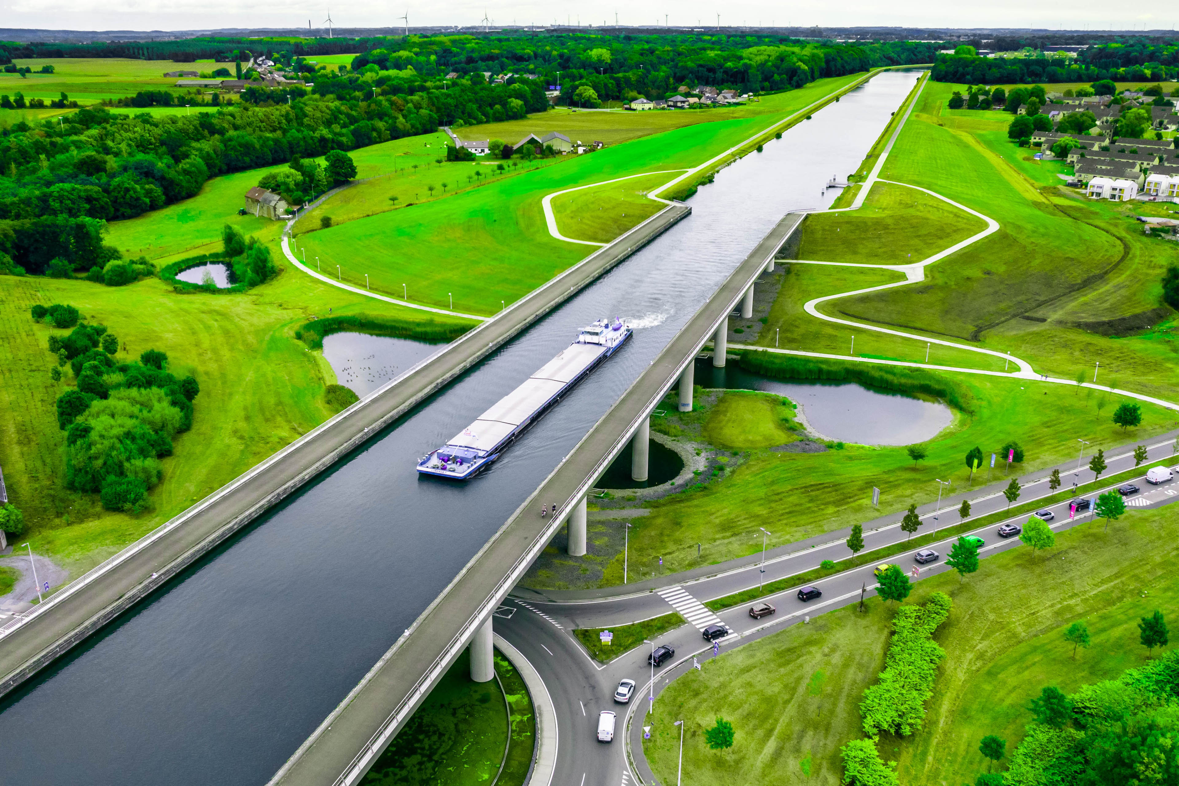 Aerial view of the Sart canal bridge crossing road in the green landscape of Belgium.