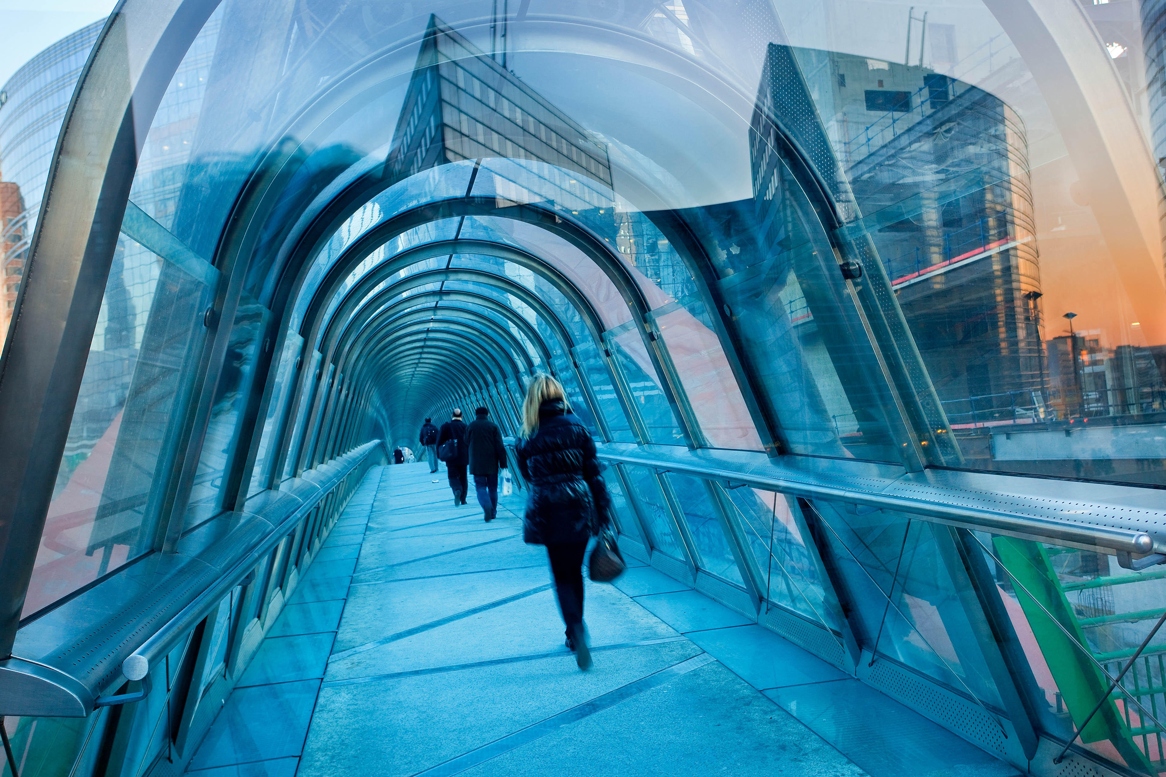 Personas caminando sobre un puente de vidrio