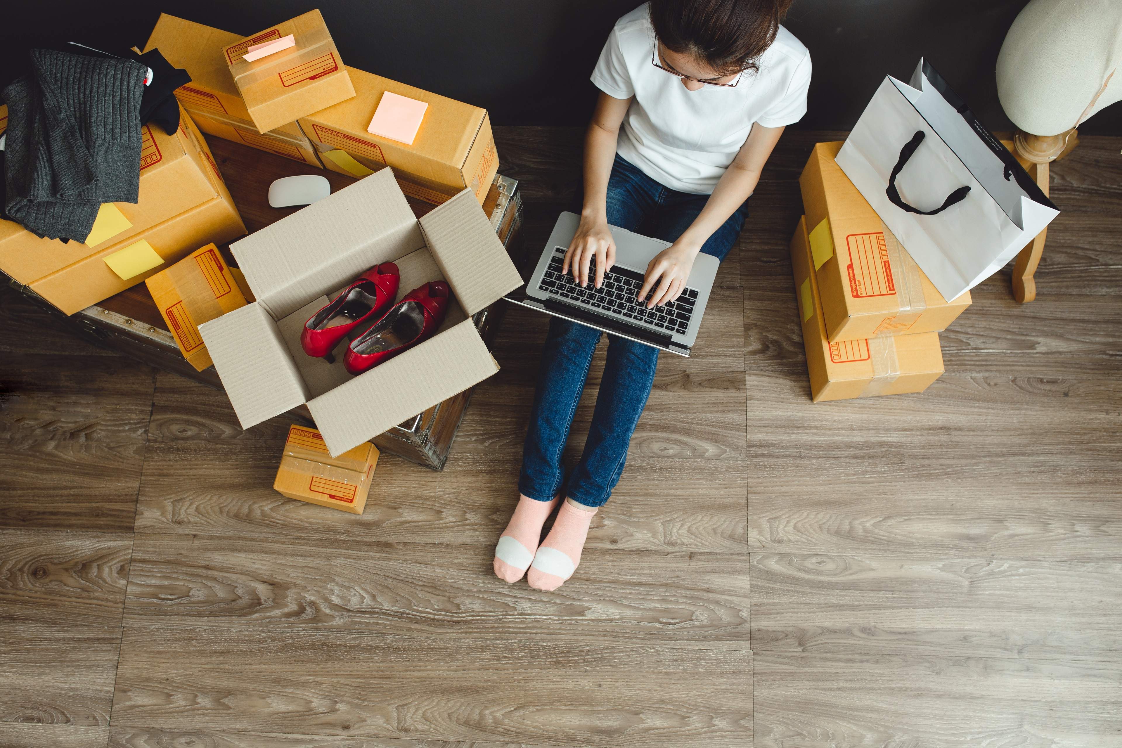 Woman working in the laptop by placing boxes around