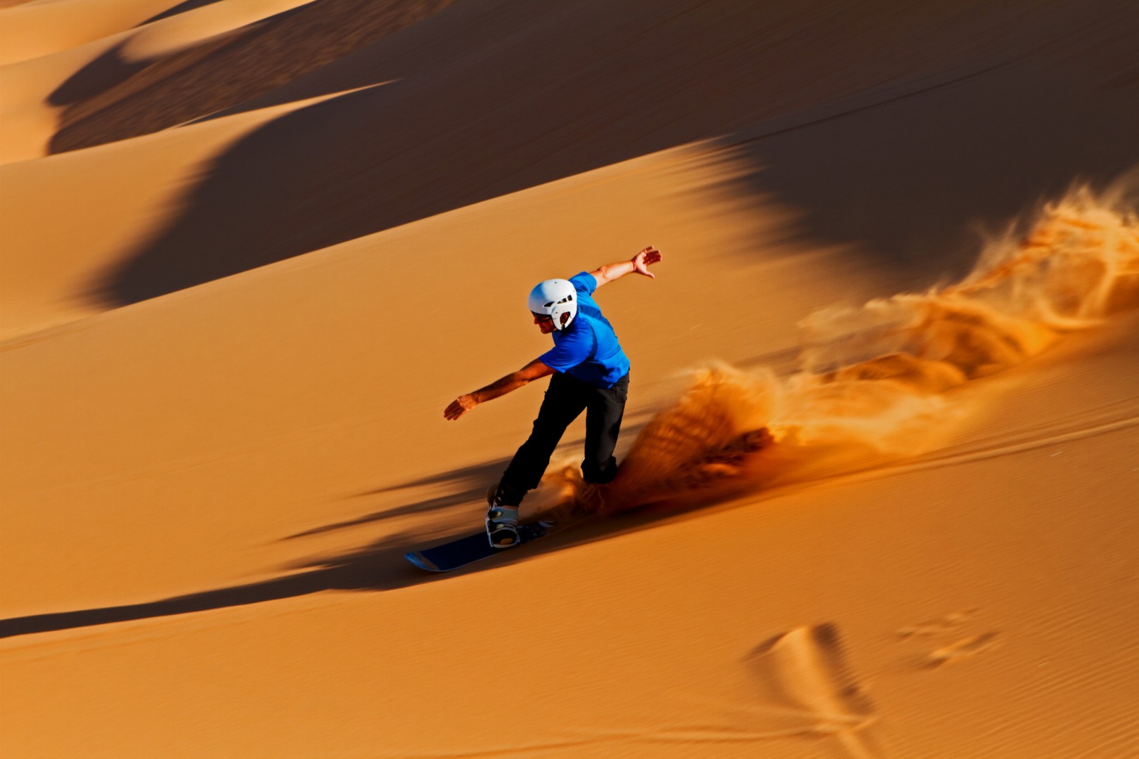 Skateboarder in sand dunes