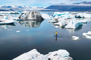 Homem velejando no meio de icebergs