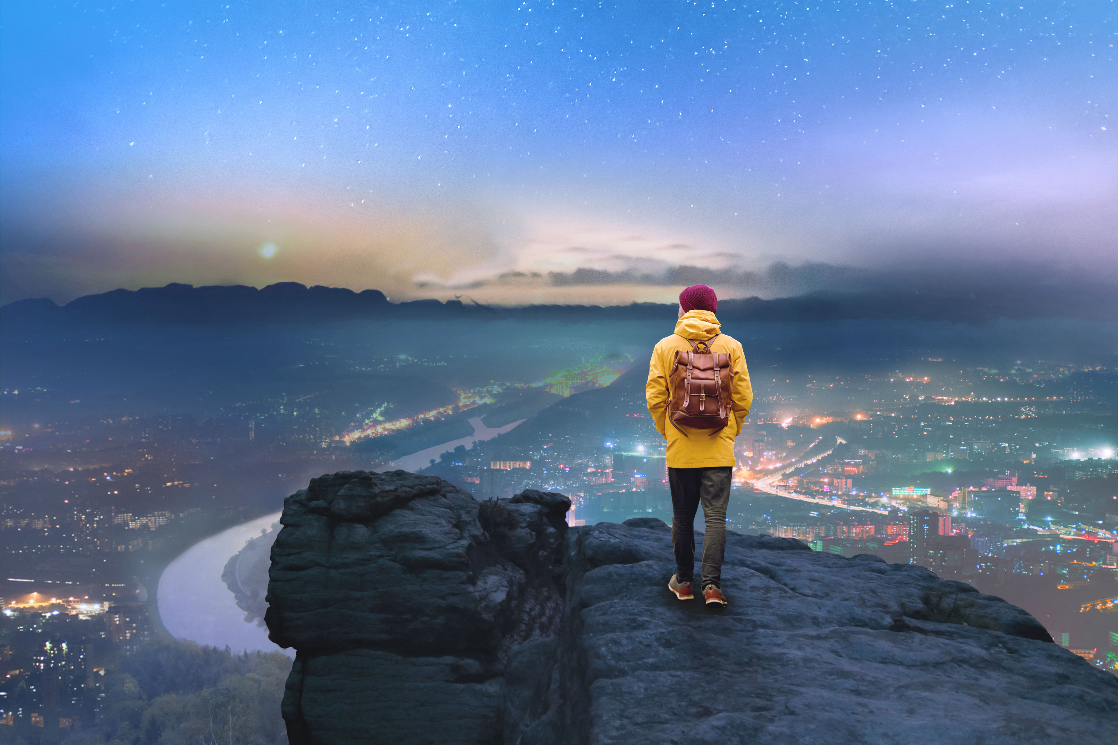 Male hiker enjoying scenic view of town and river