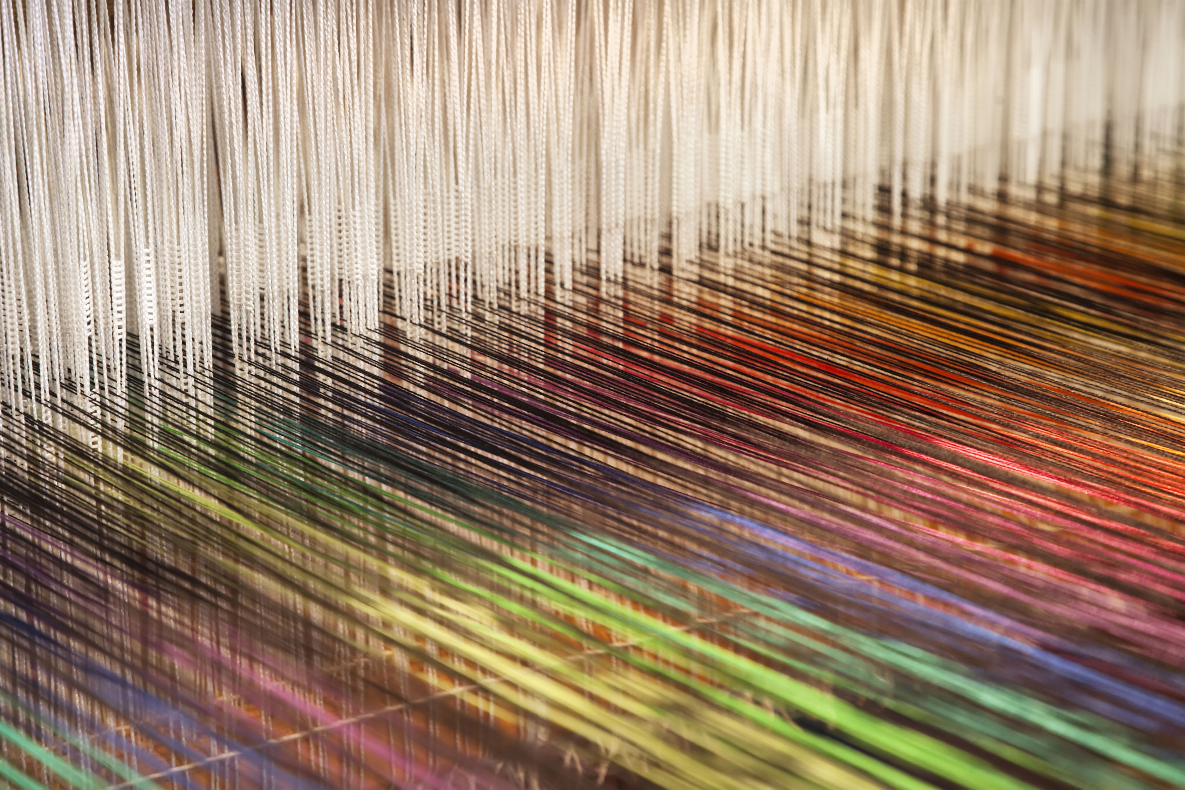 Closeup of a loom weaving colorful fabric