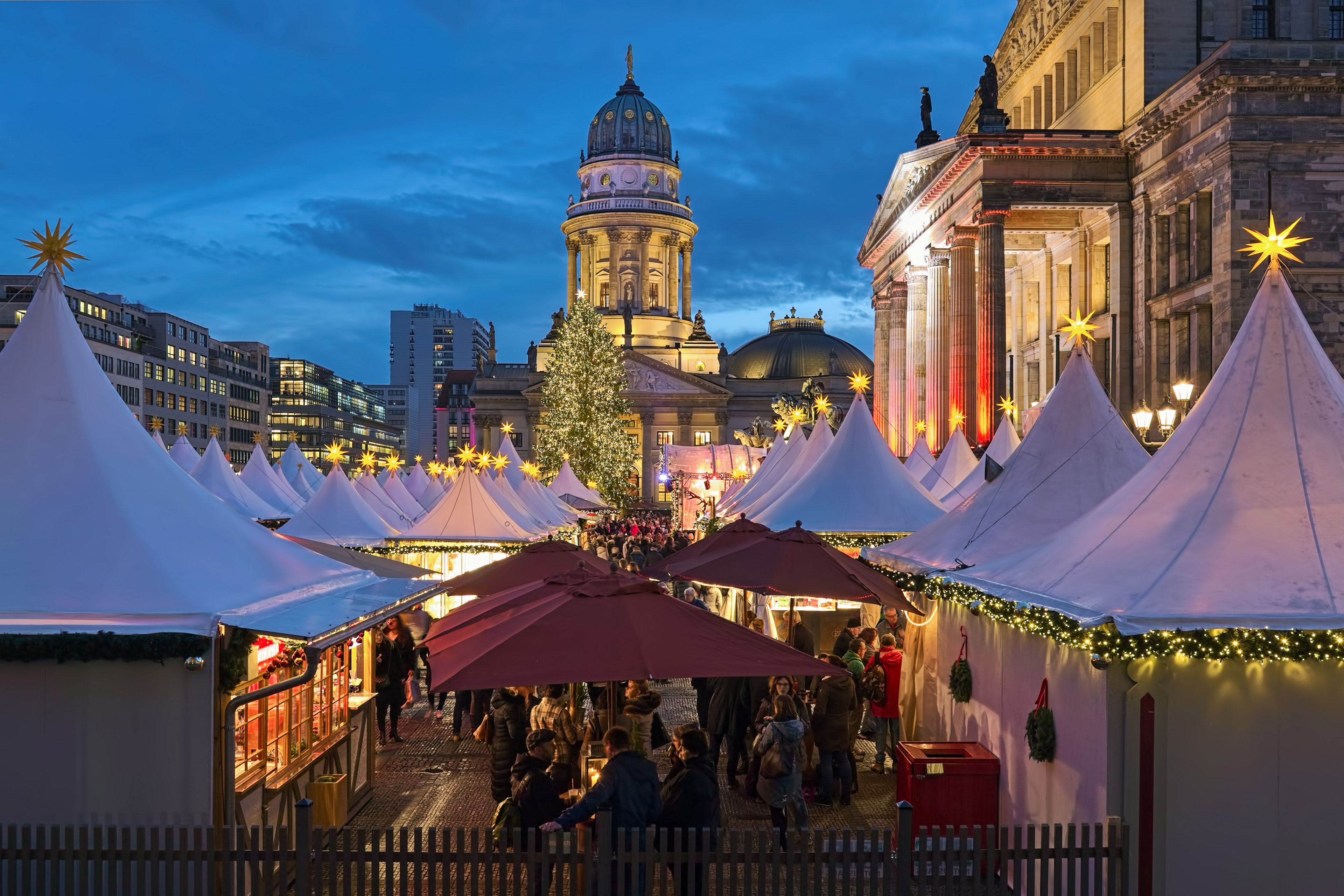 En stämningsfull julmarknad med en domkyrka i bakgrunden