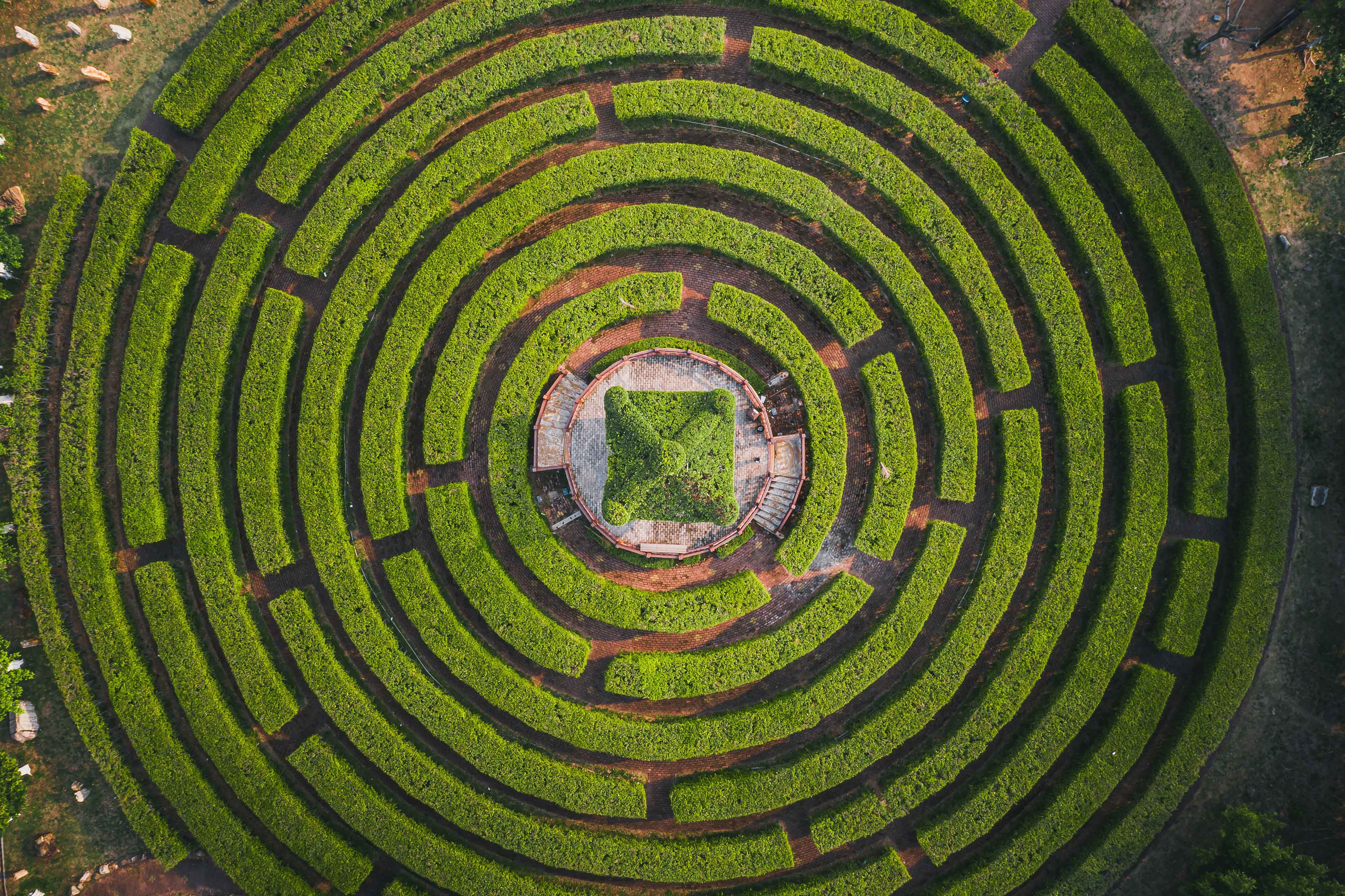 Aerial view of a circular garden maze and green pavilion