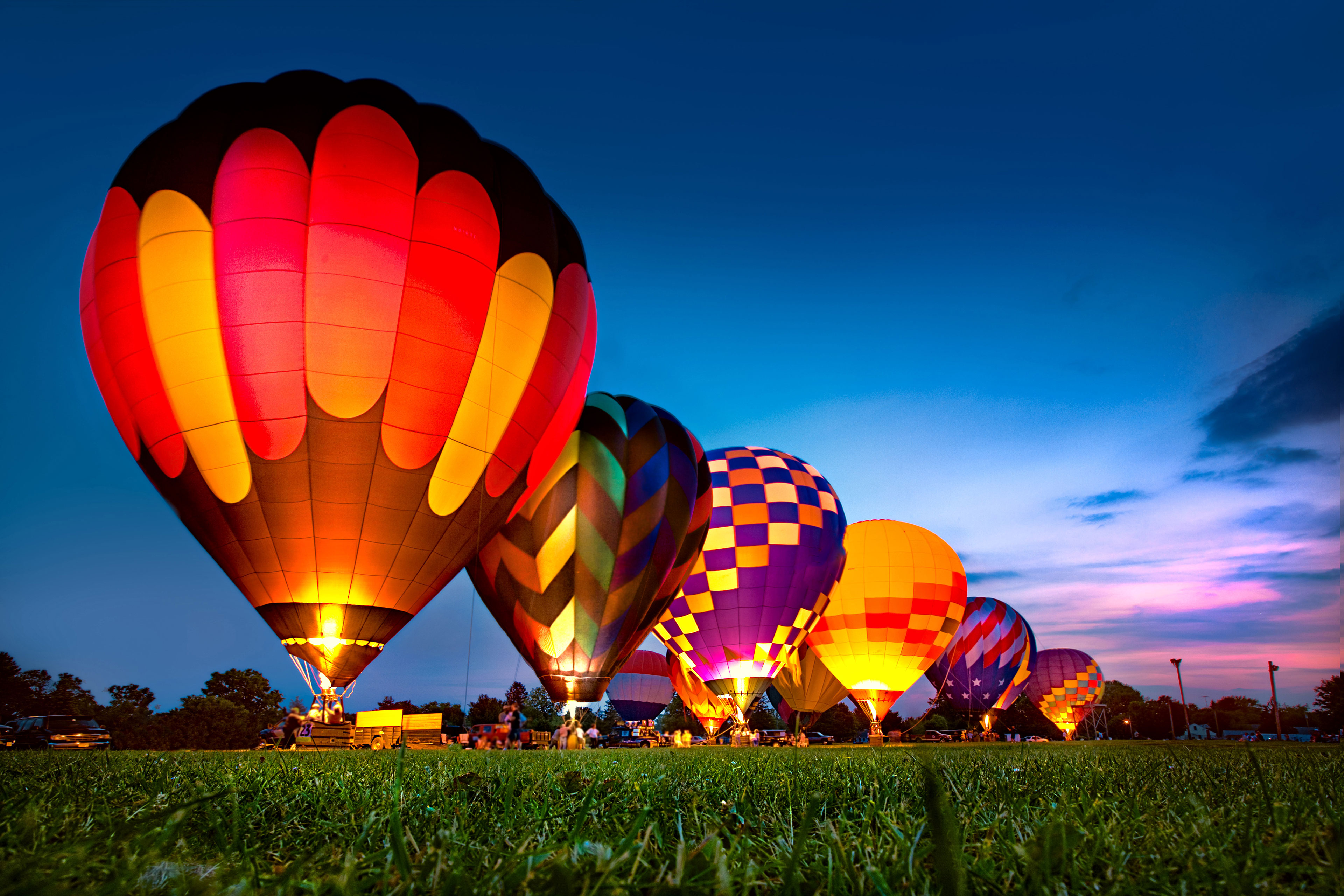 Muggy, hot, humid summer night lit by the glow of a row of hot air balloons.