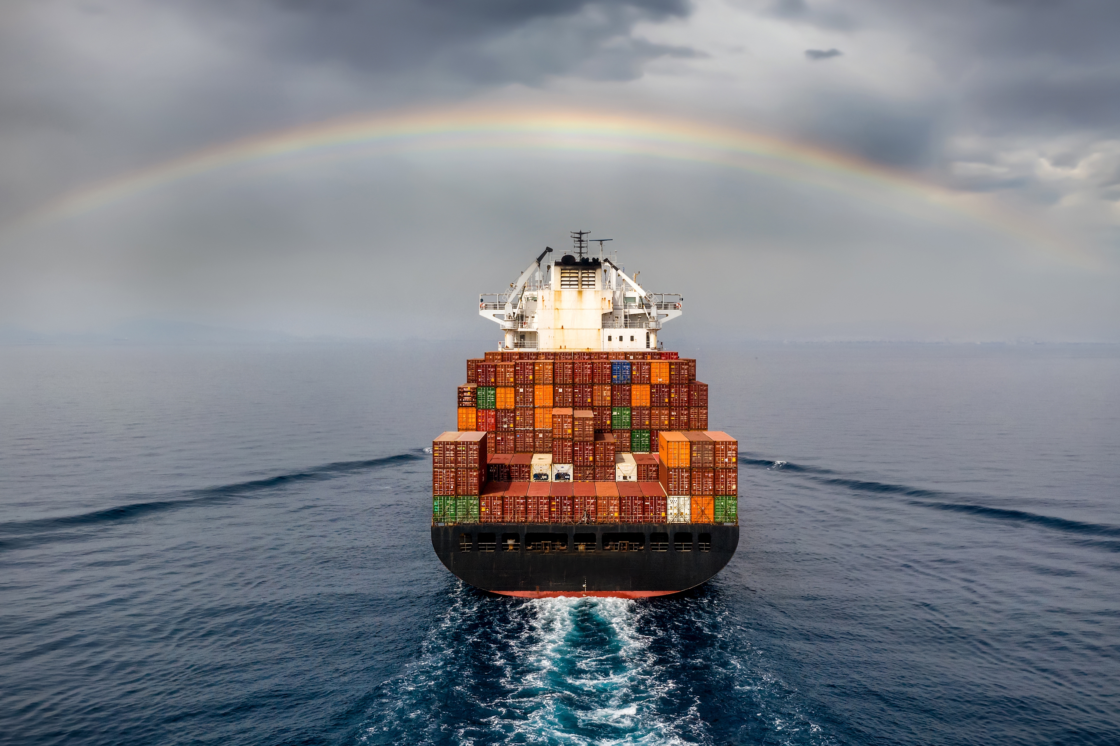 Rainbow over a container ship at sea